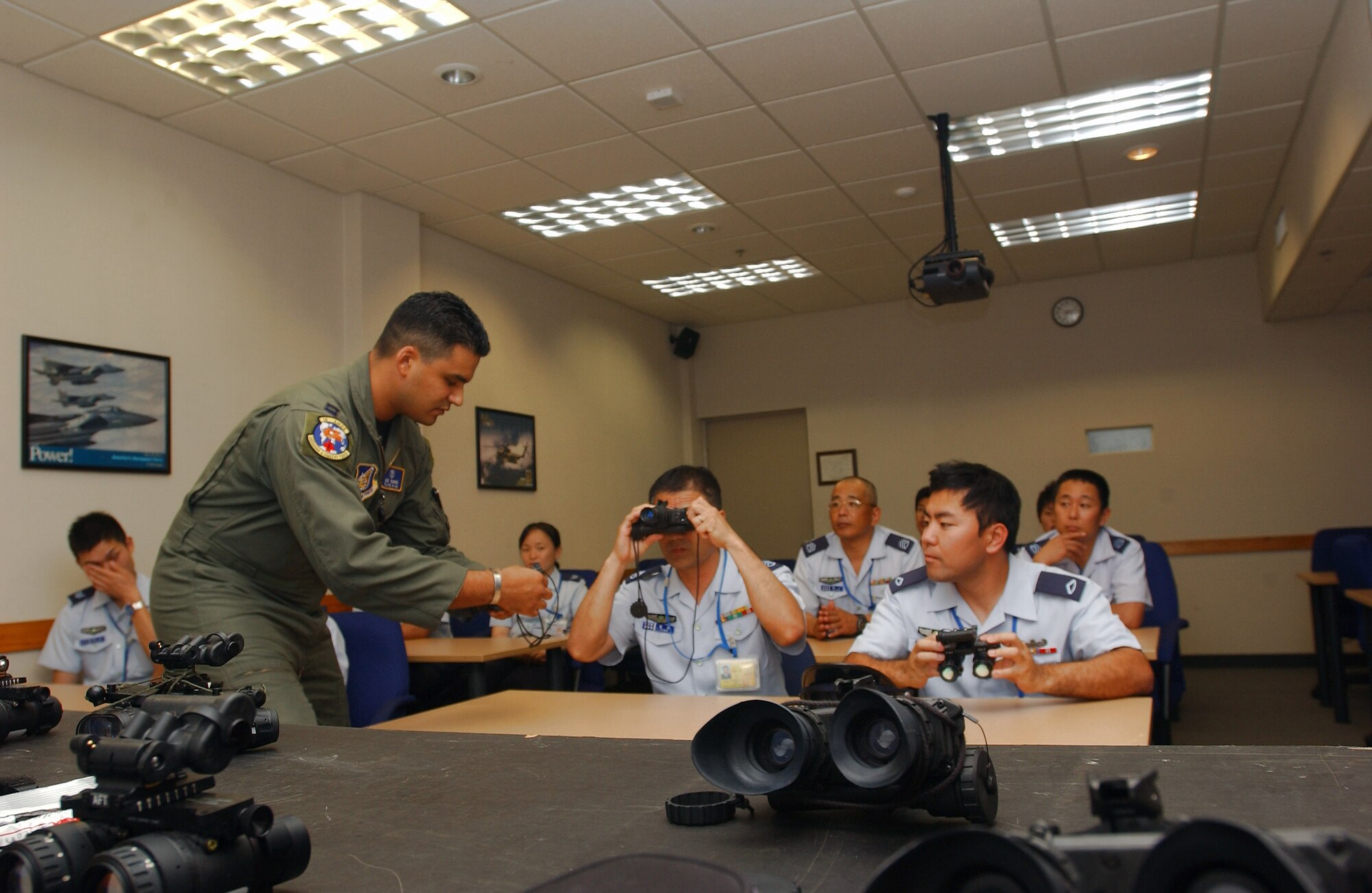 Capt. Alejandro Ramos gives a demonstratoin of night-vision technology to Japanese Air Self Defense Force airmen during an April 23 tour at Kadena Air Base, Japan. The tour was part of a bilateral arangment between 5th Air Force and the government of Japan to offer Airmen from both sides an inside look at how their counterparts do business. Captain Ramos is the 18th Aerospace Medicine Squadron officer in charge of Aerospace Physiology Operations Element .(U.S. Air Force photo/Senior Airman Jeremy McGuffin) 

