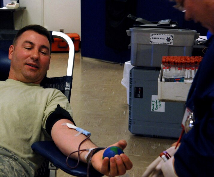 Senior Master Sgt. Peter Girtz, 372nd Training Squadron Detachment 8 chief, provides a whole blood donation for a blood drive sponsored by United Blood Services at the Entrican Center here, May 1. Sergeant Girtz repeatedly squeezes a ball provided by Shayla Bingham, United Blood Services donor care specialist and phlebotomist. The ball  quickens blood flow while speeding up the donation process.  (U.S. Air Force photo/ Airman 1st Class Abigail Klein)