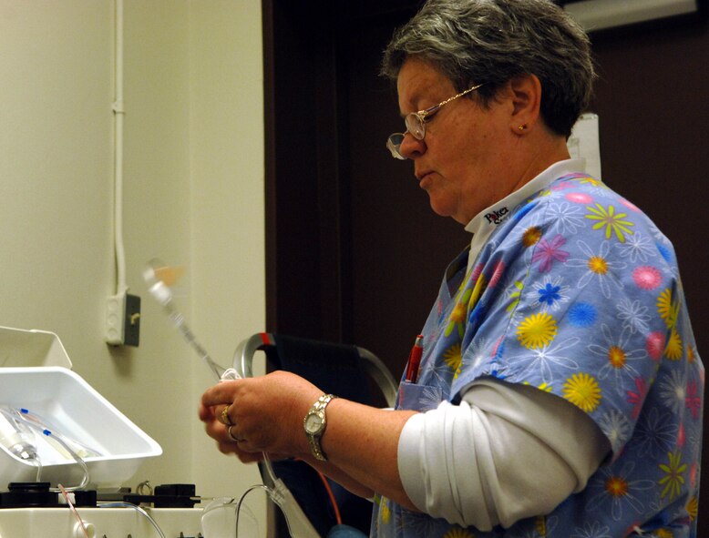 Nann Adam, United Blood Services donor care specialist and phlebotomist, prepares the automated platelet collection machine for a blood drive at the Entrican Center here, May 1. The machine supplies up to two therapeutic doses of platelets from a single donor while providing a platelet transfusion that is safe for donation recipients.  (U.S. Air Force photo/ Airman 1st Class Abigail Klein)
