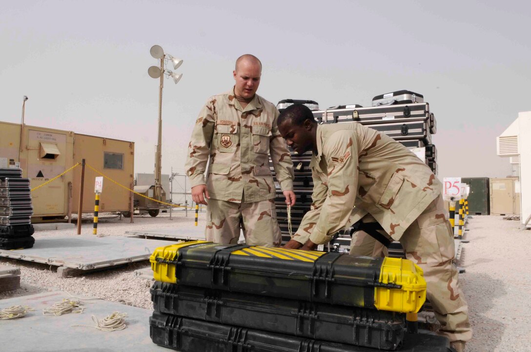Senior Airman David Fortson and Airman 1st Class Chad Bailey prepare to secure weapons onto pallets at the ammunition storage facility April 29 at a Southwest Asia air base. Airmen of the Expeditionary Theater Distribution Center secure and store weapons for more than 10,000 deployed members each month. Airmen Fortson and Bailey are assigned to the 379th Expeditionary Logistics Readiness Squadron. (U.S. Air Force photo/Tech. Sgt. Johnny Saldivar) 