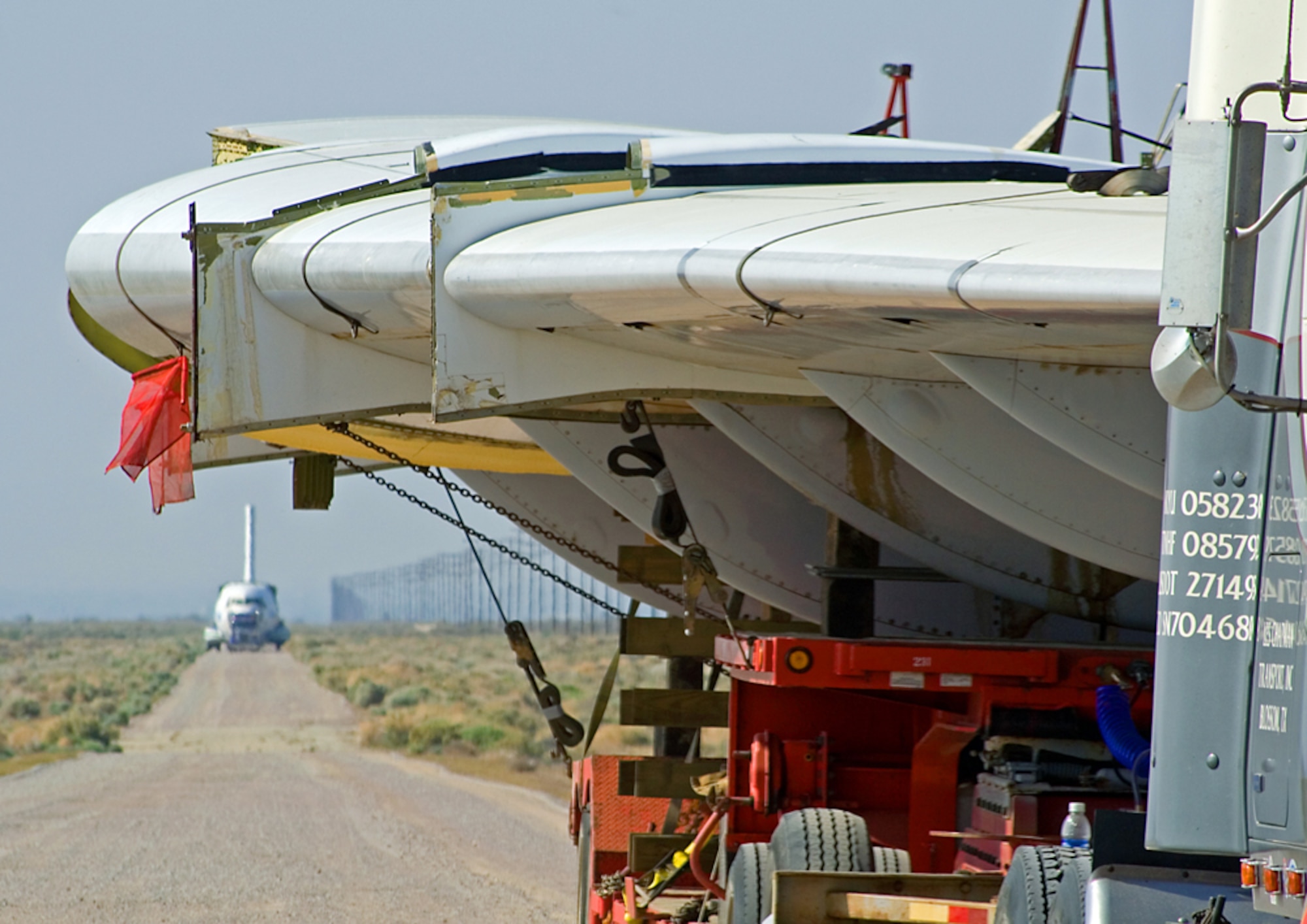 A YC-15 wing load sits stationary as the aircraft's fuselage approaches on Shuttle Road here April 4. The aircraft returned to Edwards to be part of the Century Circle museum annex near the West Gate. (Air Force photo by Fred Johnsen)