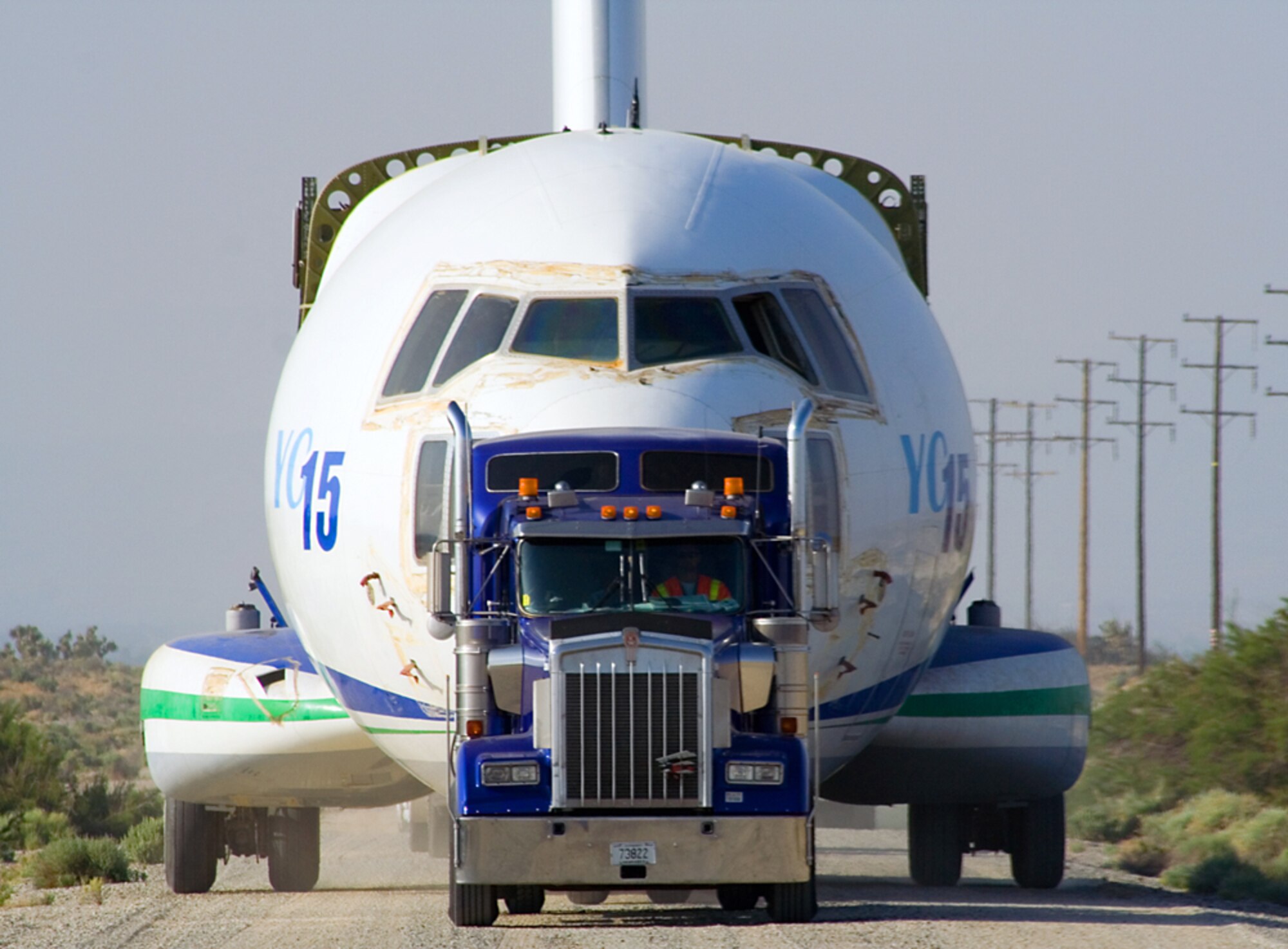Contractors move a YC-15 fuselage along Shuttle Road here April 4. The aircraft returned to Edwards to be part of the Century Circle museum annex near the West Gate. The YC-15 was one of two prototypes built by McDonnell Douglas in response to an Air Force interest in developing an advanced medium short takeoff and landing transport to replace the C-130 Hercules. (Air Force photo by Fred Johnsen)