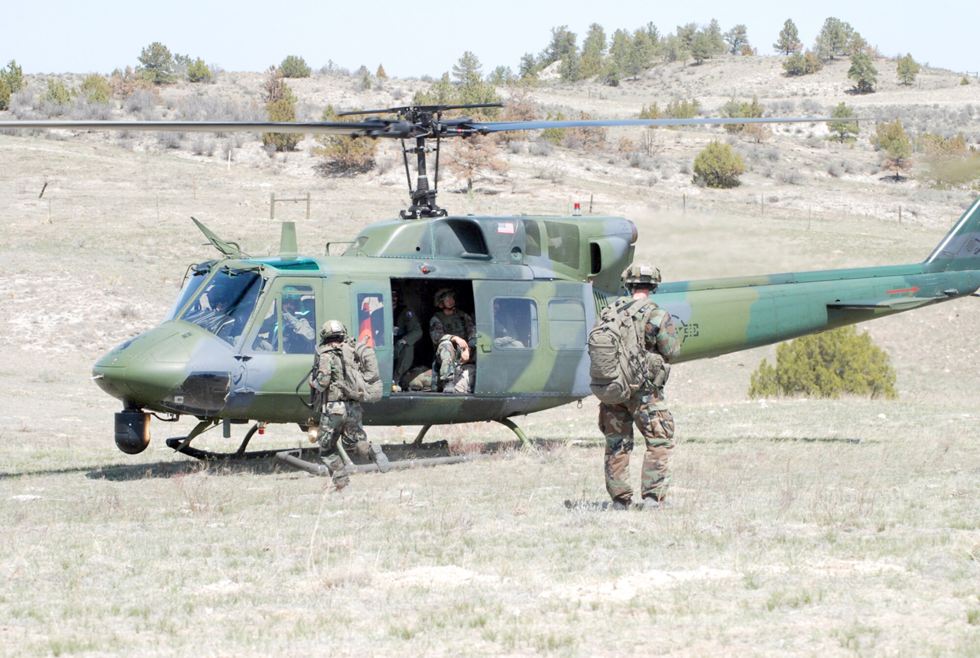 The security forces members run to the helicopter after securing the classified material.