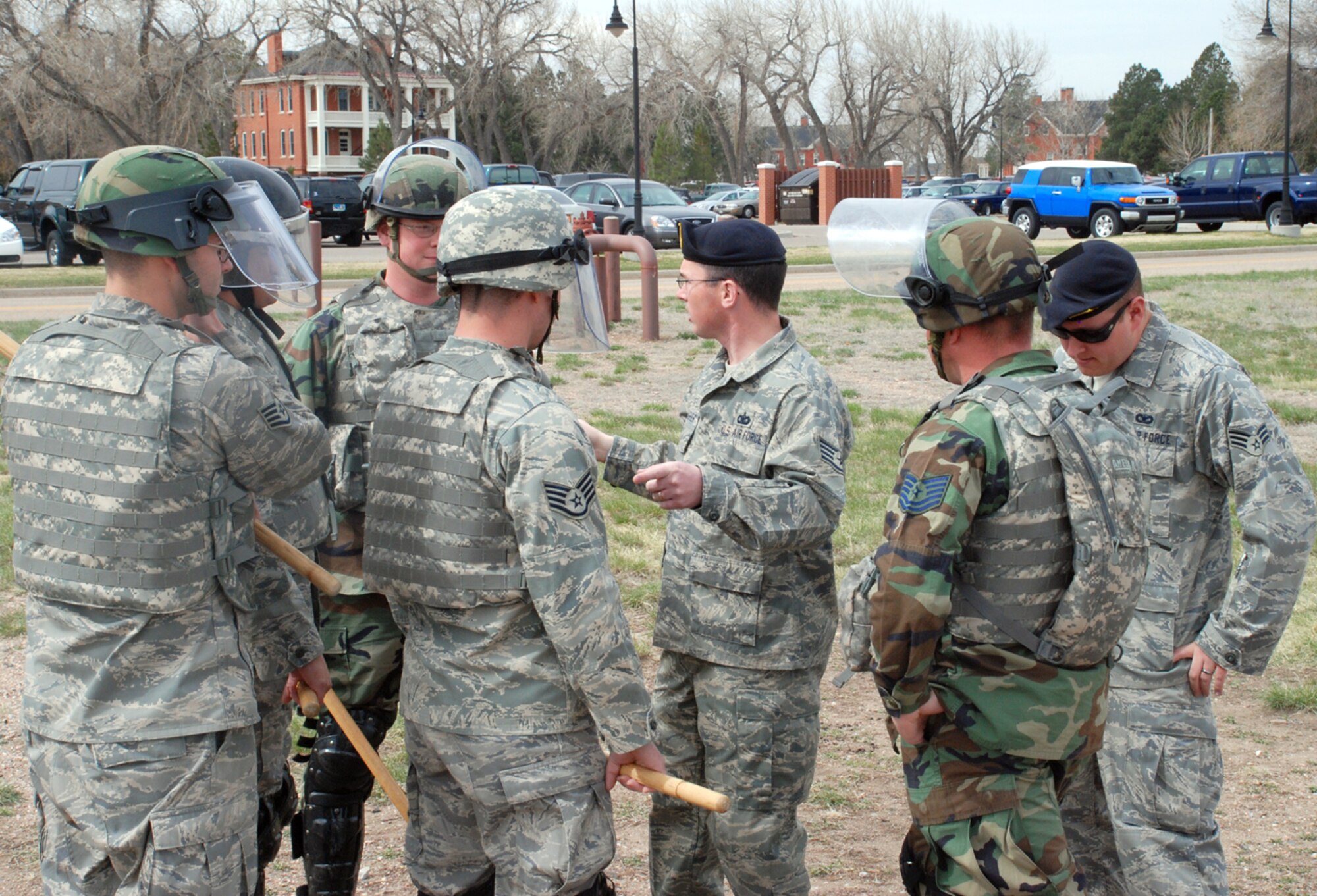 Staff Sgt. Kevin Gallagher (center), 90th Security Support Squadron, briefs the NCOs of 90th MSFS Flight One before the confrontation training. Safety was a concern for the training because the Airmen were using riot gear and wooden batons. The protective red suits are designed to reduce physical stress, but caution is needed.