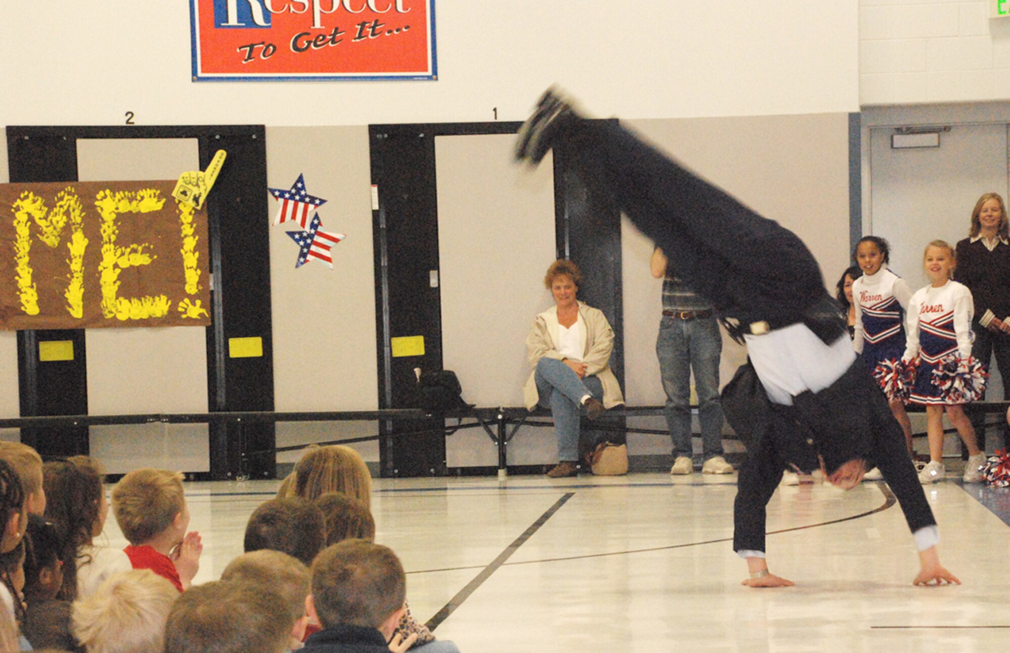 Col. Brian Hayes, 90th Medical Group commander, performs cartwheels before the children at the Month of the Military Child gathering in Freedom Elementary April 25. Colonel Hayes was a guest speaker.