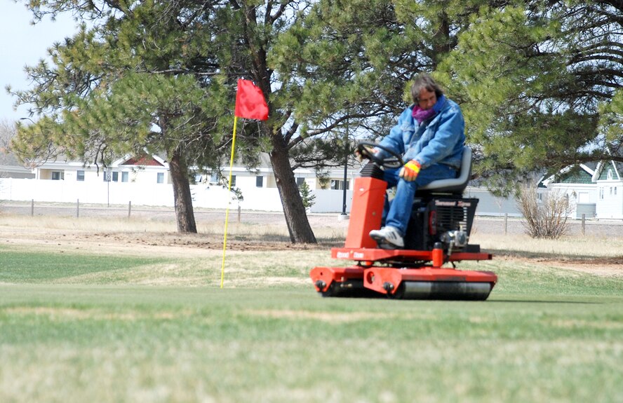 Greg Litecky, Warren Golf Club ground crew operator, rides a rolling machine over the second-hole green April 24. The machine helps smooth out the green, and makes the green putt faster. Mr. Litecky was working to prepare the greens for a 30th Airlift Squadron golf tournament. For more information or  to make a tee time, call 773-3556 (U.S. Air Force photo/Staff Sgt. Chad Thompson).