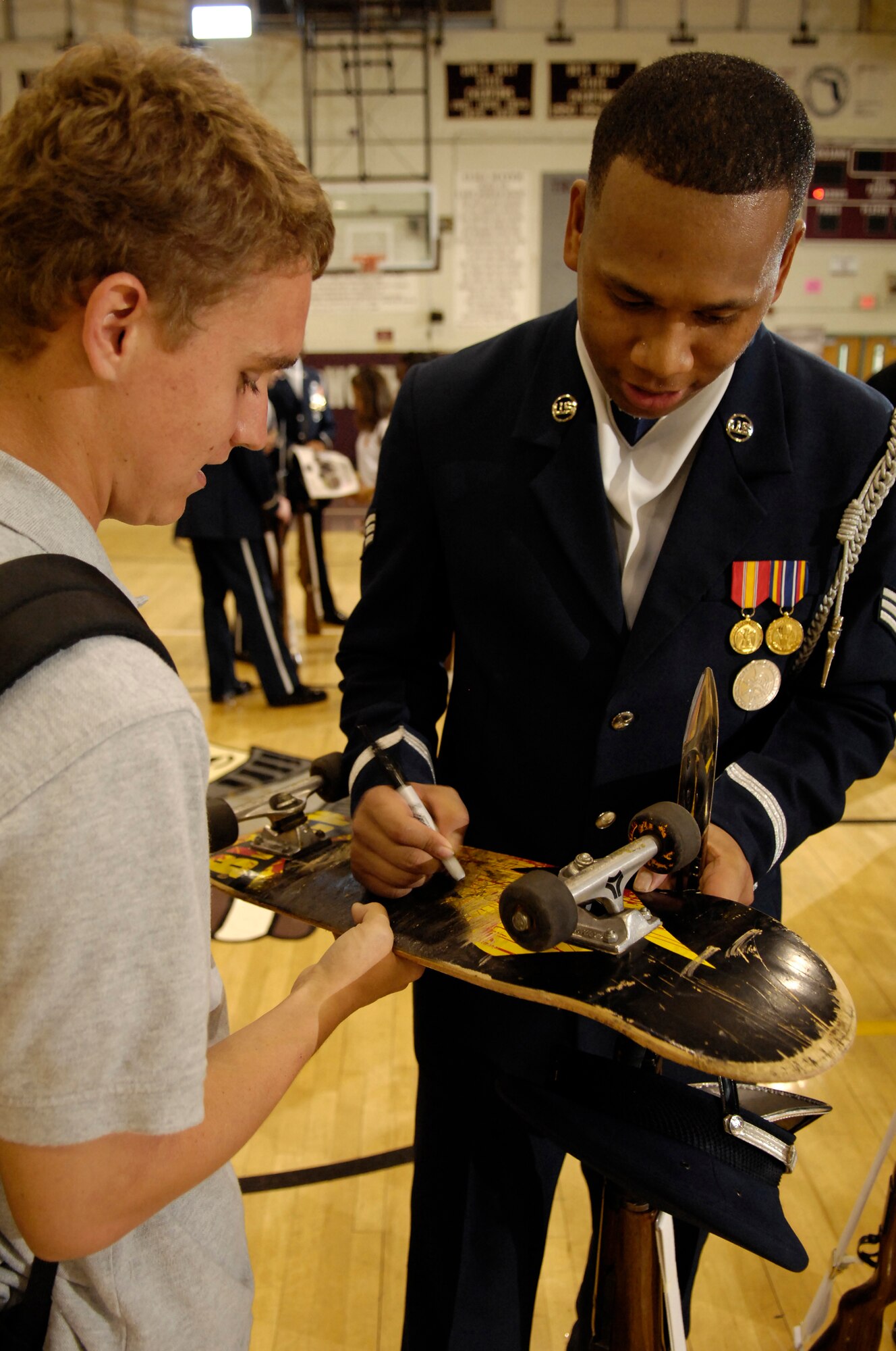 Senior Airman Keith Jones, Drill Team member, signs an autograph for a Lake Worth High School student after perfoming in Lake Worth, Fla. 2 May. The Drill Team is the traveling component of the Air Force Honor Guard and tours world-wide representing all Airmen and showcasing USAF precision to recruit, retain, and inspire for the Air Force mission. (U.S. Air Force photo by Senior Airman Dan DeCook)(Released)