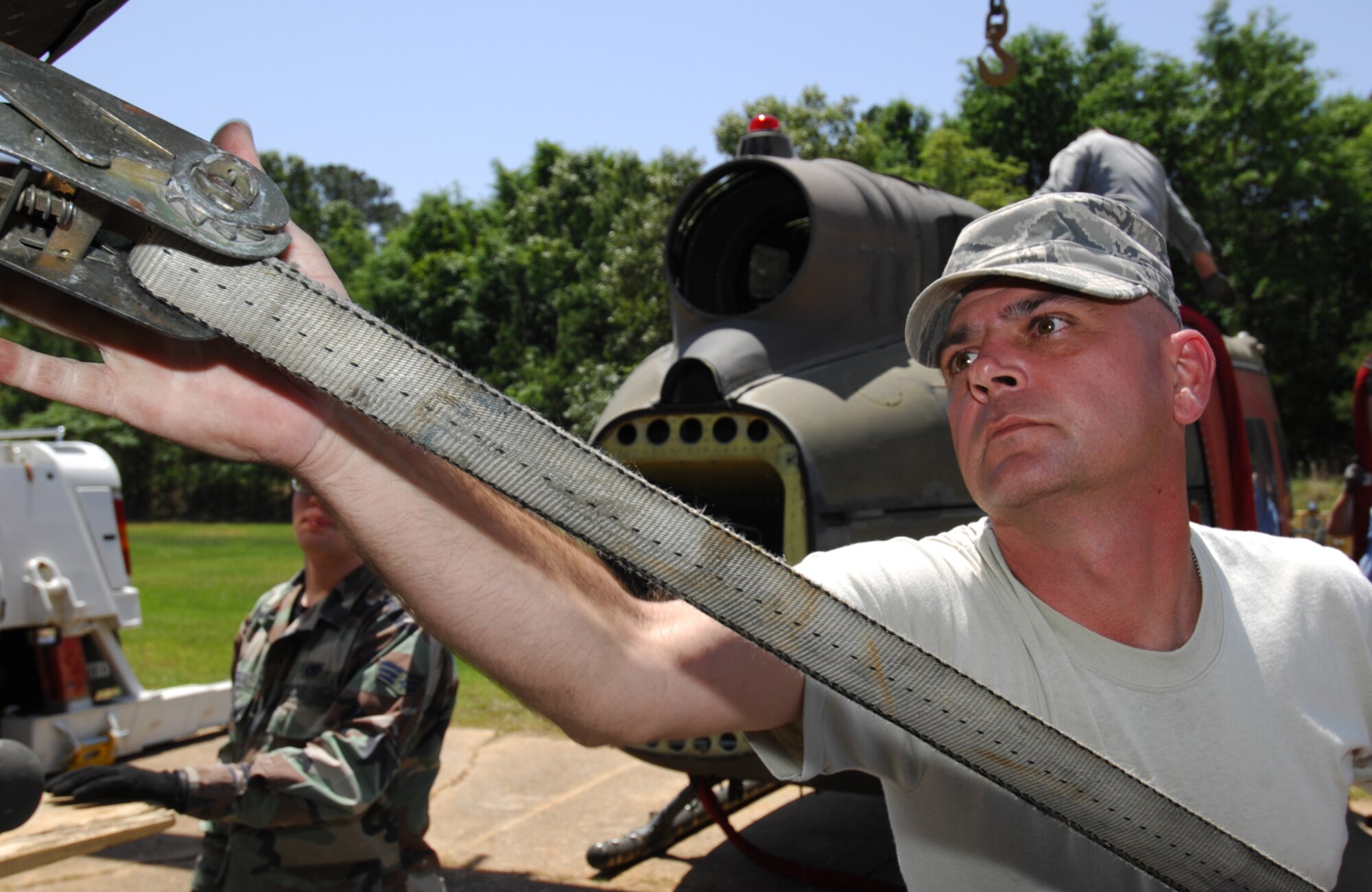 FT. RUCKER, Al. - Technical Sgt. Reagan Ross, of the 23rd Logistics Readiness Squadron, secures the decomissioned fuselage of a UH-1 Huey helicopter to a semi truck tailer at Fort Rucker, Al. on April 30. Five UH-1 helicopter fuselages will be transported by truck to Moody and used to enhance the combat search and rescue readiness of the 23rd Wing. (U.S. Air Force photo by Staff Sgt. Joshua T Jasper)