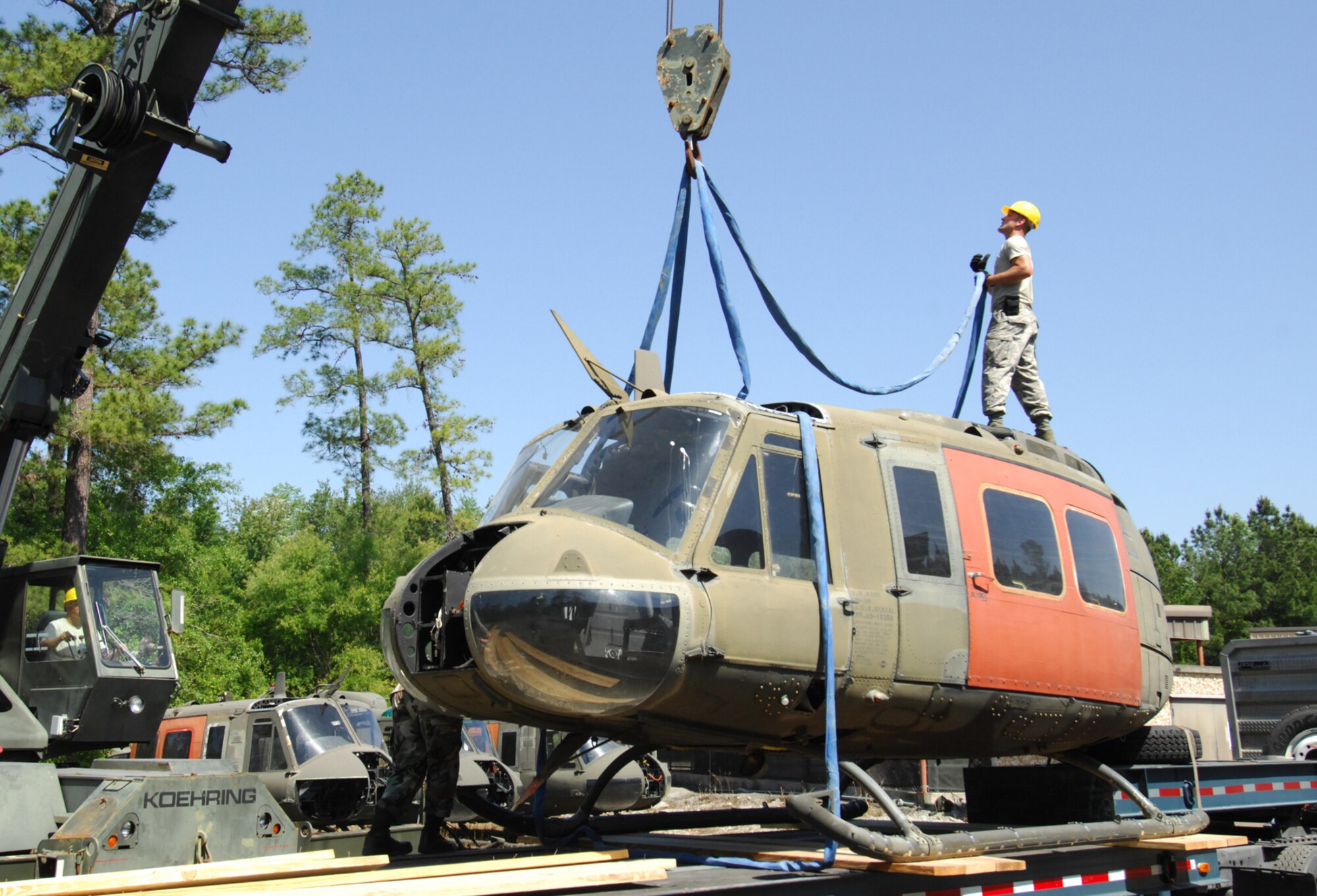 MOODY AIR FORCE BASE, Ga. - Staff Sgt. Jeffrey Huber of the 23rd Logistics Readiness Squadron, prepares to secure a crane hook and lifting strap to a decomissioned UH-1 Huey helicopter fuselage on May 2, Five UH-1 helicopter fuselages have been transported here from Ft. Rucker Al. and will be unloaded and used to enhance Moody's combat search and rescue readiness.  (U.S. Air Force photo by Staff Sgt. Joshua T Jasper)