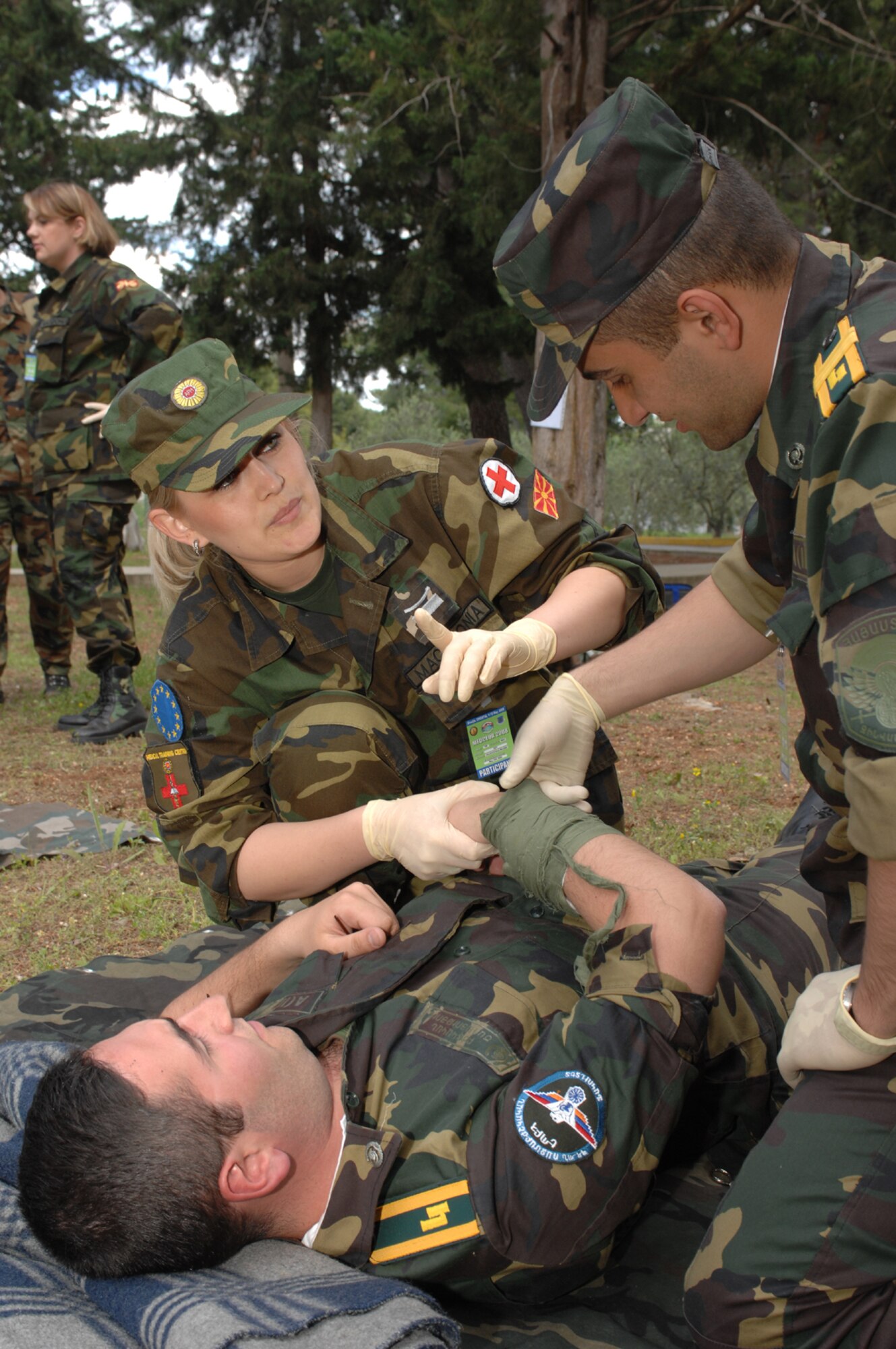 DIVULJE TRAINING BASE, Croatia – Macedonian Army Sgt. Milena Velickovska discusses different techniques of Self Aid Buddy Care May 3 with cadets Vahe Petrosyan (lying down) and Arsen Adonc from the Military Medicine Faculty of the Armenian Medical University during the 2008 Medical Training Exercise in Central and Eastern Europe (MEDCEUR). The Self Aid Buddy Care course is one of eleven courses offered during MEDCEUR.   Fifteen nations are participating in the exercise from May 2 through 14. The exercise focuses on mass-casualty training scenarios and humanitarian aid in response to crises situations. MEDCEUR is a Joint Chiefs of Staff regional/multilateral exercise sponsored by U.S. European Command. Croatia is hosting the 2008 exercise which has drawn about 400 multi-nationals in support of the Partnership for Peace initiative. (U.S. Air Force photo/Staff Sgt. Kristin Ruleau)