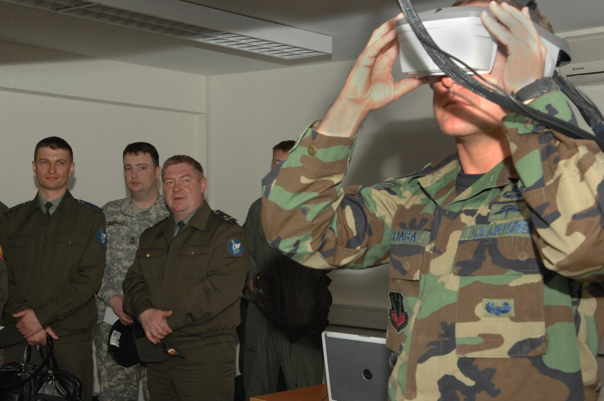 Lt. Col. Sergey Izvenkov and Col. Aleksandu Razygraeu, Russian distinguished visitors, observe as Tech. Sgt. Timothy Pachasa, guest Joint Terminal Attack Instructor at USAFE Air Ground Operations School from Ft. Bliss, Texas, demonstrates the use of the Indirect Fire Forward Air Control Trainer simulator, a procedural trainer that simulates close air support and indirect fires. The demonstration was at the Joint Fighters Center for Excellence on Spangdahlem AB, Germany, April 30, 2008. (United States Air Force Photo by Senior Airman Logan Tuttle)