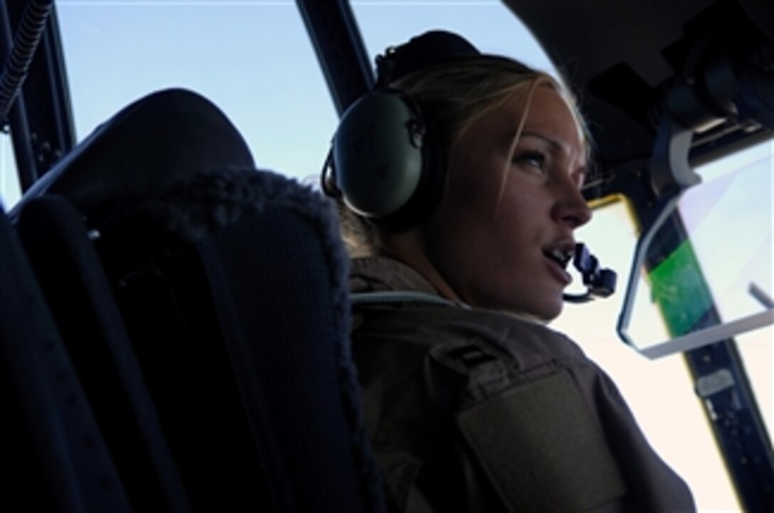 U.S. Air Force Capt. Sheila Carlson talks on the radio in the cockpit of a C-130J Hercules aircraft at Bagram Air Field, Afghanistan, on May 1, 2008.  Carlson is a pilot assigned to the 774th Expeditionary Airlift Squadron and deployed from the 115th Airlift Squadron, Channel Island Air National Guard Station, California Air National Guard, Port Hueneme, Calif.  