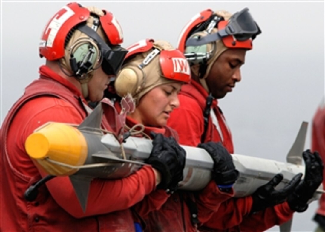 Aviation Ordnancemen assigned to the "Bounty Hunters" of Strike Fighter Squadron 2 download an AIM-9X Sidewinder Missile from an F/A-18F Super Hornet on the flight deck of the USS Abraham Lincoln, Persian Gulf, April 30, 2008, after the completion of a mission. 