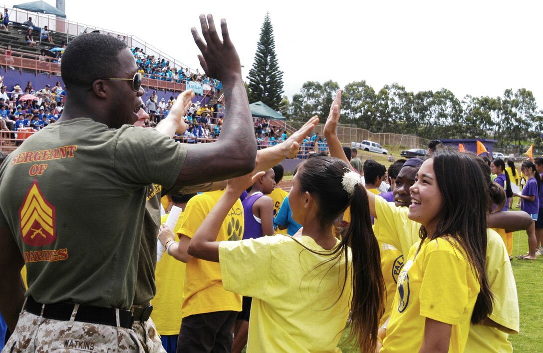 PEARL CITY, Hawaii --  Sgt Lavonne Watkins, EKMS alternate manager, G-6, MARFORPAC, dishes out some high fives after a relay race at an elementary school field meet at Pearl City High School May 5.  (Official Marine Corps photo by Sgt. Scott Whittington)