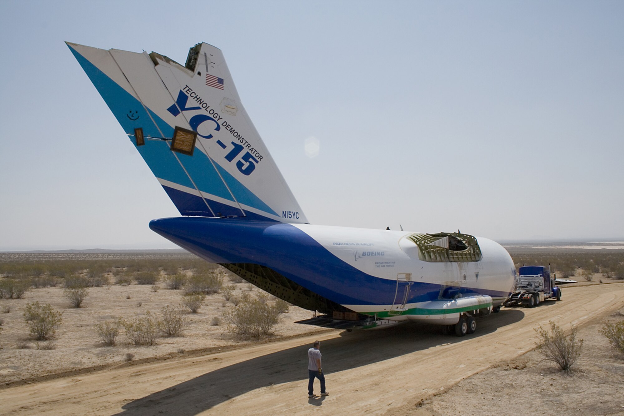 Contractors transport a YC-15 fuselage near the West Gate here April 4. The aircraft returned to Edwards to be part of the Century Circle museum annex at the gate. (Air Force photo by Fred Johnsen)