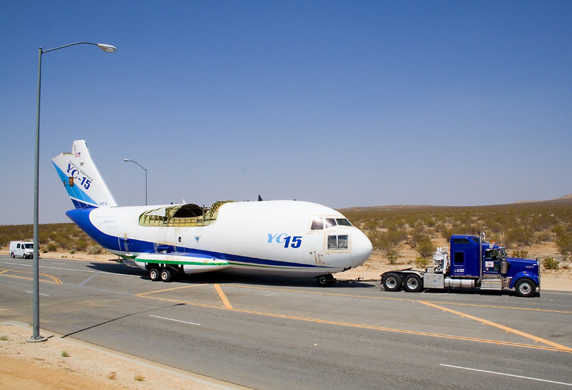 Contractors tow a YC-15 fuselage down Rosamond Boulevard here April 4. The aircraft will become part of the Century Circle museum annex at the West Gate. The YC-15 was one of only two prototypes built by McDonnell Douglas in response to an Air Force interest in developing an advanced medium short takeoff and landing transport to replace the C-130 Hercules. (Air Force photo by Fred Johnsen)