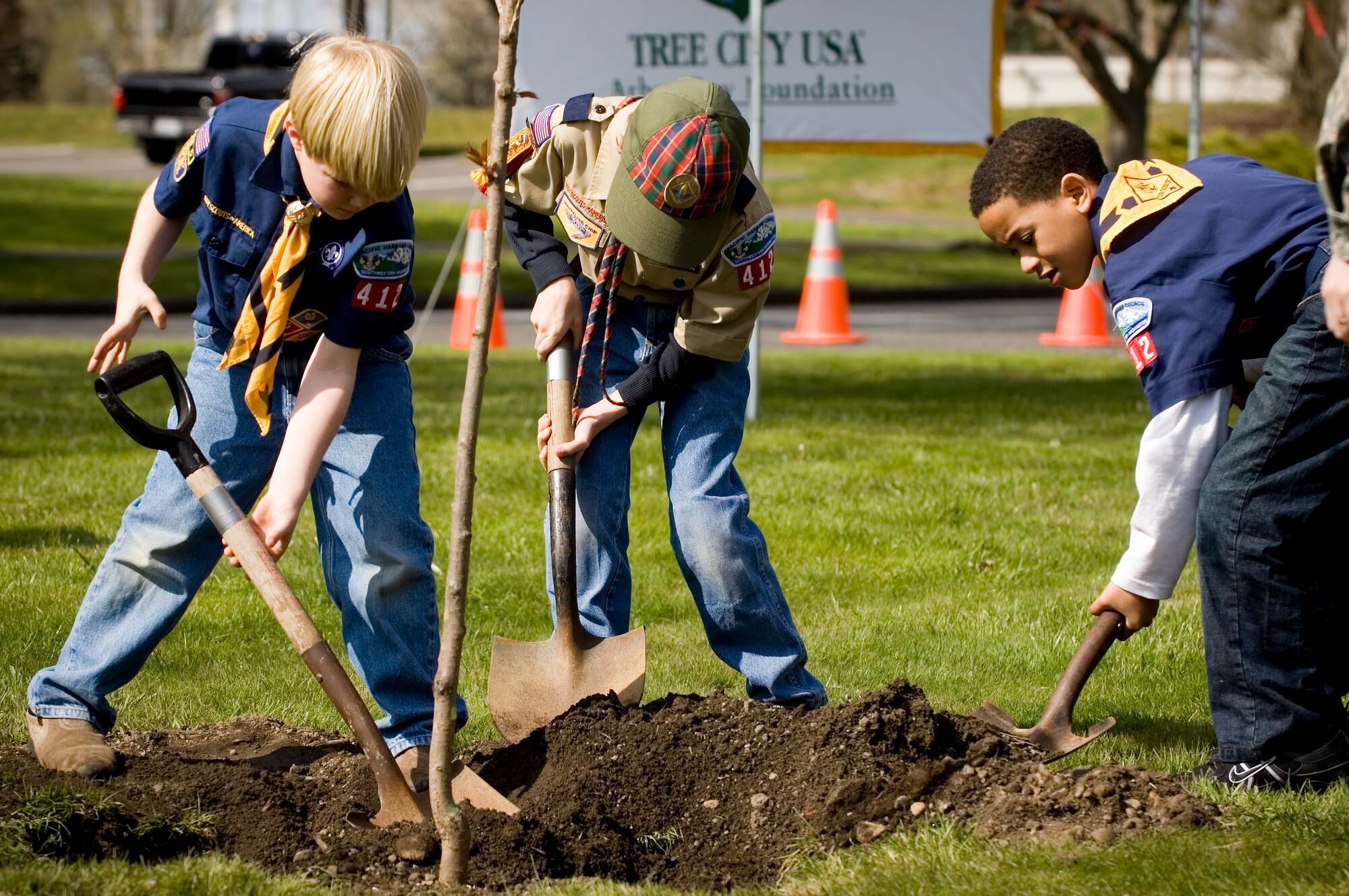 Cub scouts, from left, Jackson Elder, 7; Jeremy Rechner, 9; and Seth Cowart, 8, plant a tree during McChord's Arbor Day celebration April 25 alongTuskegee Airman Boulevard. During the celebration McChord also received its 15th consecutive Tree City USA award.