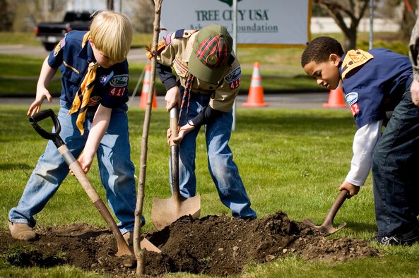Cub scouts, from left, Jackson Elder, 7; Jeremy Rechner, 9; and Seth Cowart, 8, plant a tree during McChord's Arbor Day celebration April 25 alongTuskegee Airman Boulevard. During the celebration McChord also received its 15th consecutive Tree City USA award.