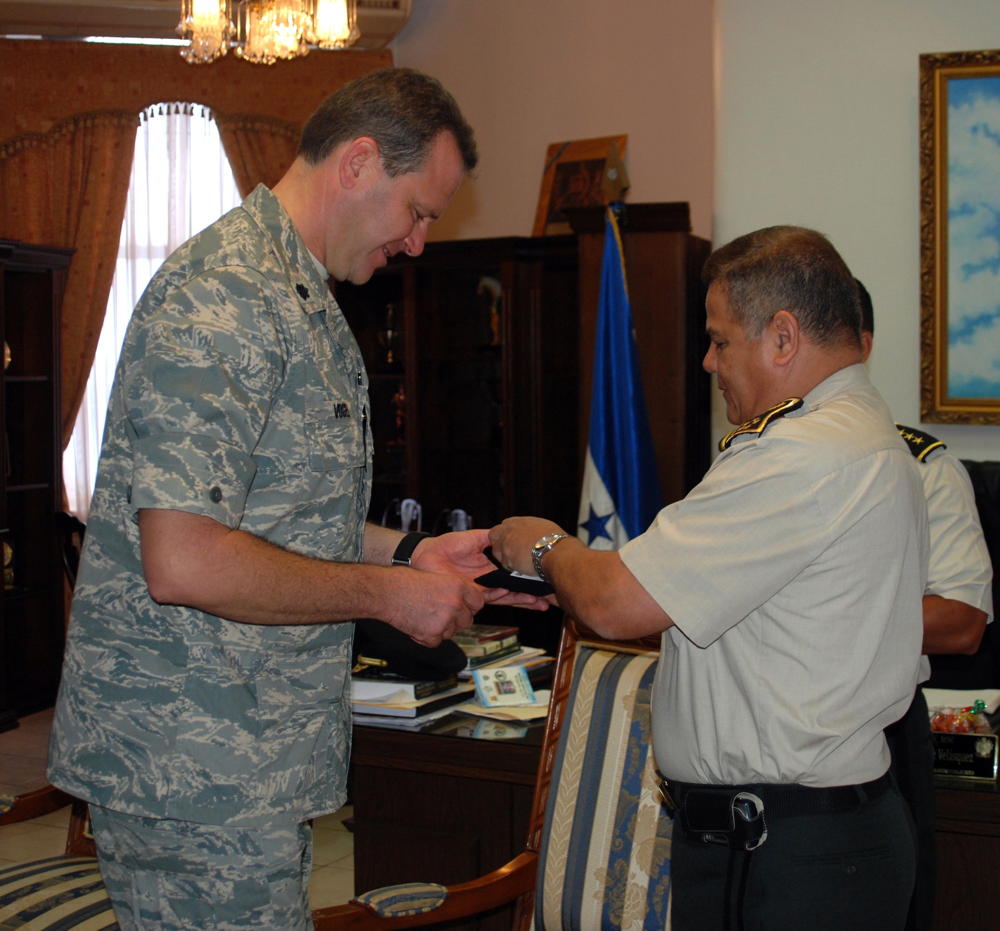 Air Force Lt. Col. Randall Vogel receives a coin from Honduran Chief of Defense, General de Division Romeo Orlando Vasquez Velasquez, during a ceremony May 5 in Tegucigalpa Honduras. Colonel Vogel and two others from JTF-Bravo receved Honduran Medals of Merit. Colonel Vogel is the 612th Air Base Squadron commander at Soto Cano Air Base, Honduras. (U.S. Air Force photo/Tech. Sgt. John Asselin)