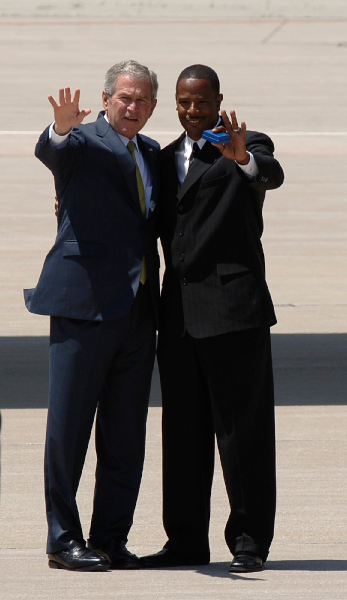 MCCONNELL AIR FORCE BASE, Kan. -- President George W. Bush and Buddy Shannon, a humanitarian from Wichita, wave to a crowd of McConnell members on the flightline, May 4. The president presented him with the ‘President’s Call to Service Award” for his volunteer efforts with the “Real Men, Real Heroes program. Mr. Shannon is amongst 32 African-American men in the program, who serve as mentors and role models to struggling young boys in the local community.  (Photo by Airman 1st Class Maria Ruiz)