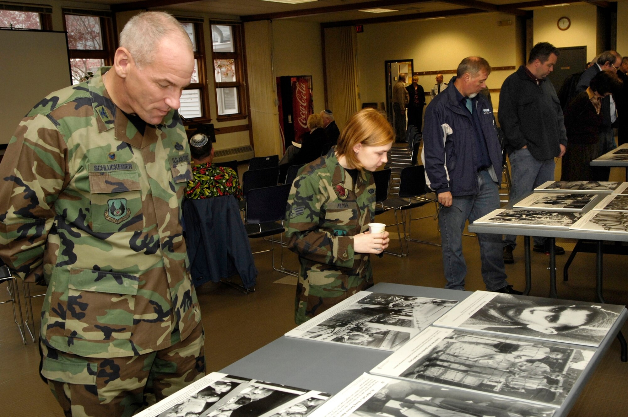 HANSCOM AFB, Mass. -- 66th Air Base Wing Commander Col. Tom Schluckebier (left), Senior Airman Danielle Flynn, Air Force Band of Liberty, and other members of the Hanscom community view Holocaust photo displays at the Base Chapel.  The displays were part of the Holocaust Remembrance Day ceremony, held May 2. (U.S. Air Force photo by Mark Wyatt)