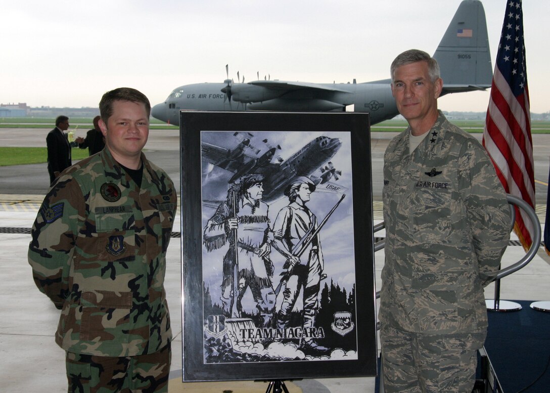 NIAGARA FALLS AIR RESERVE STATION, N.Y. - Staff Sgt. Daniel Lanphear (left), Air Force Reserve and Maj. Gen. Robert Knauff, commander of the New York Air National Guard pose in front of Staff Sgt. Lanphear's hand-sketched artwork which portrays the unity between the Guard and Reserve at Niagara.  The Frontiersman on the left side of the artwork represents the 914th Airlift Wing (AFRC) and the Minuteman on the right represents the 107th Airlift Wing (NYANG).  Standing over Niagara Falls, they symbolize Citizen Airmen united in defense of our nation.  The C-130 represents the units' combined combat flying mission and this artwork commemorates the first ever Reserve/Guard C-130 association.  (U.S. Air Force photo / Tech. Sgt. Christopher Boswell)