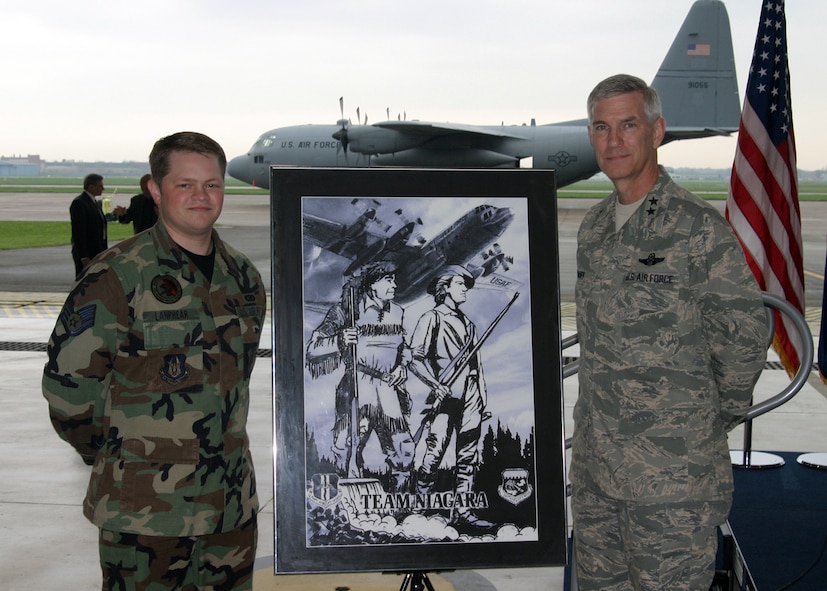 NIAGARA FALLS AIR RESERVE STATION, N.Y. - Staff Sgt. Daniel Lanphear (left), Air Force Reserve and Maj. Gen. Robert Knauff, commander of the New York Air National Guard pose in front of Staff Sgt. Lanphear's hand-sketched artwork which portrays the unity between the Guard and Reserve at Niagara.  The Frontiersman on the left side of the artwork represents the 914th Airlift Wing (AFRC) and the Minuteman on the right represents the 107th Airlift Wing (NYANG).  Standing over Niagara Falls, they symbolize Citizen Airmen united in defense of our nation.  The C-130 represents the units' combined combat flying mission and this artwork commemorates the first ever Reserve/Guard C-130 association.  (U.S. Air Force photo / Tech. Sgt. Christopher Boswell)