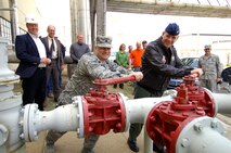 MINOT AIR FORCE BASE, N.D. -- Col. Joel Westa, 5th Bomb Wing commander (right), and Lt. Col. Brian May, 5th Civil Engineering Squadron commander shut off the main gas line into the 51-year-old heat plant here April 30.  The heat plant started operation in June of 1957 and was one of the first buildings completed on base. (U.S. Air Force photo by Airman First Class Kelly Timney)