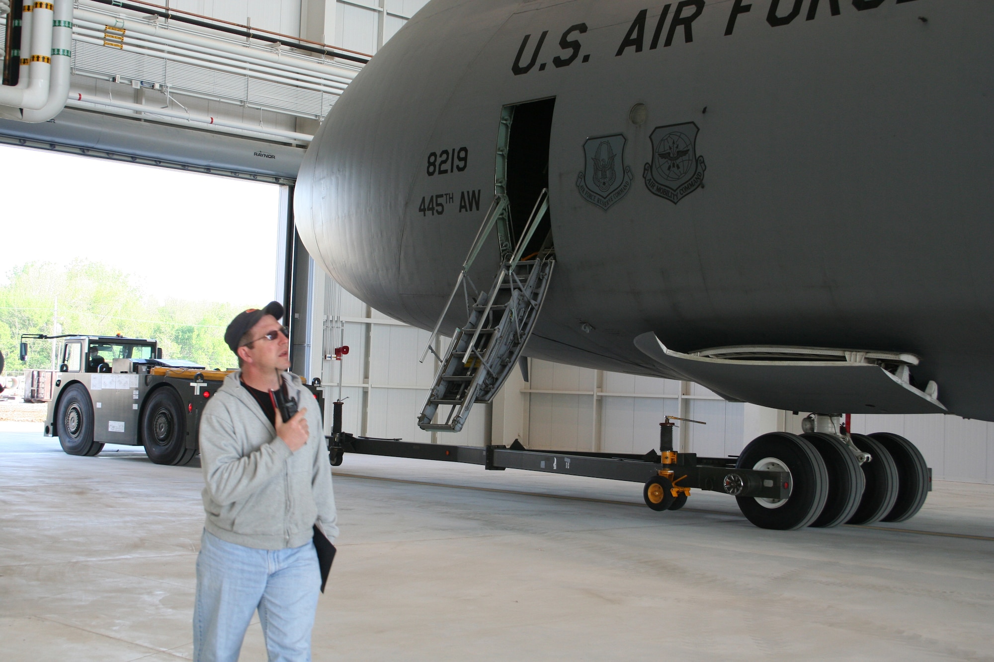 WRIGHT-PATTERSON AFB, Ohio - Master Sgt. Doug Werner, 445th Aircraft Maintenance Squadron, is on the radio as a C-5 Galaxy is pulled for a fit test into the third and final hangar to be completed as part of the 445th Airlift Wing's large construction project to support the C-5 aircraft since their conversion began.  This hangar includes staff, shops, and tool crib areas used primarily for scheduled maintenance. (U.S. Air Force photo/Mary Allen)   