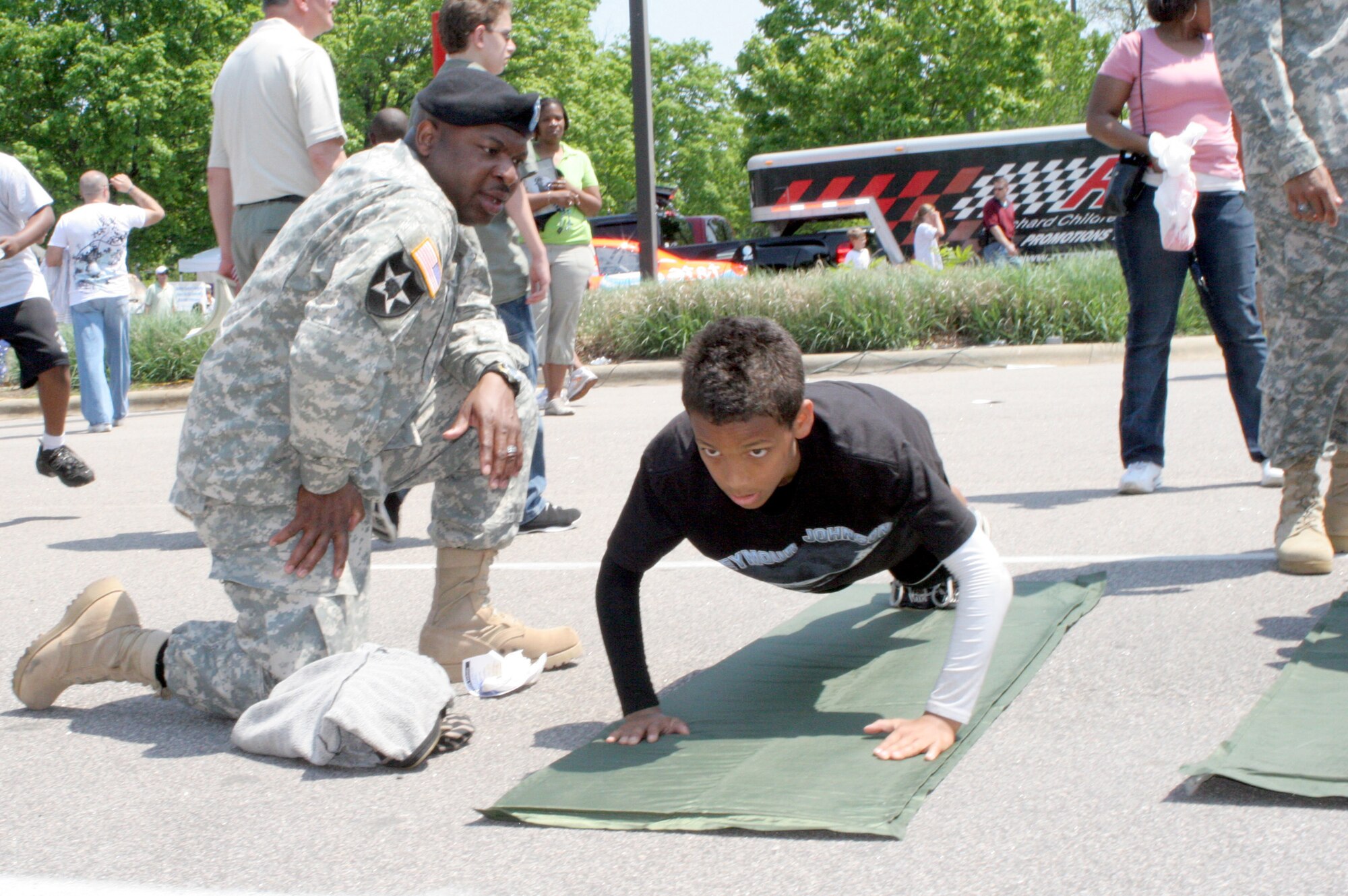 RALEIGH, N.C. - CPT Sherlock McDougald, 1st Battalion, 323rd Regiment in Durham, NC urges on Quentin Stevenson to complete the physical training exercise set up as part of the displays for Salute the Troops in Raleigh April 26. The event, which garnered more than 50,000 spectators, honored the members of the military in North Carolina and featured a parade, lunch, entertainment, and special displays of weaponry, armored vehicles, marine rescue and other equipment throughout the day. (US Air Force Photo by Capt Tana R.H. Stevenson)  