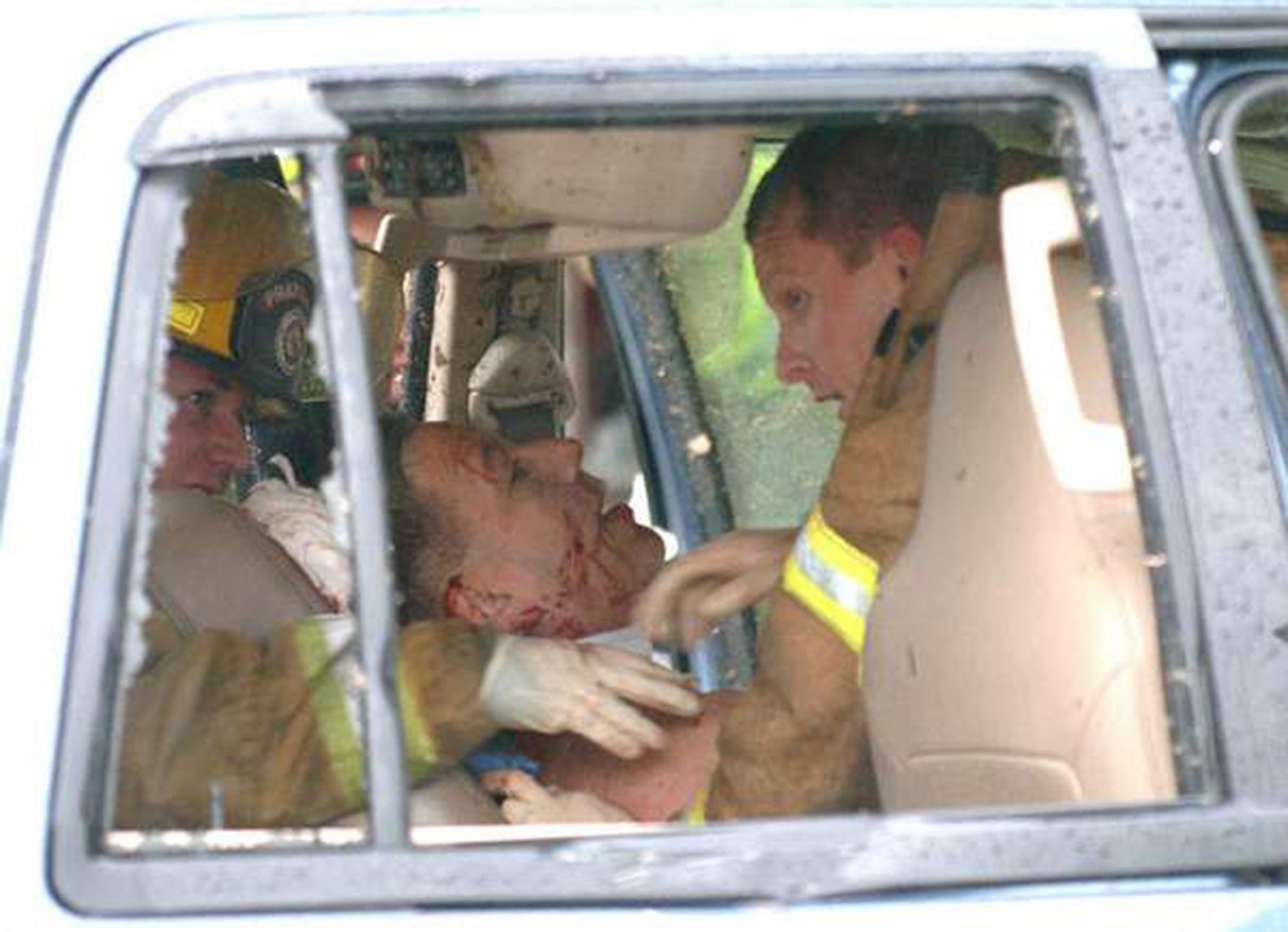 Trying to stabilize his neck and spine, firefighter Jared Maners and fire medic Roy Simpson carefully put a neck brace on Navy Commander Carl Forkner, who was critically injured when the EF-3 tornado slammed into his vehicle. (Photo by Lloyd Gallman, Montgomery Advertiser)