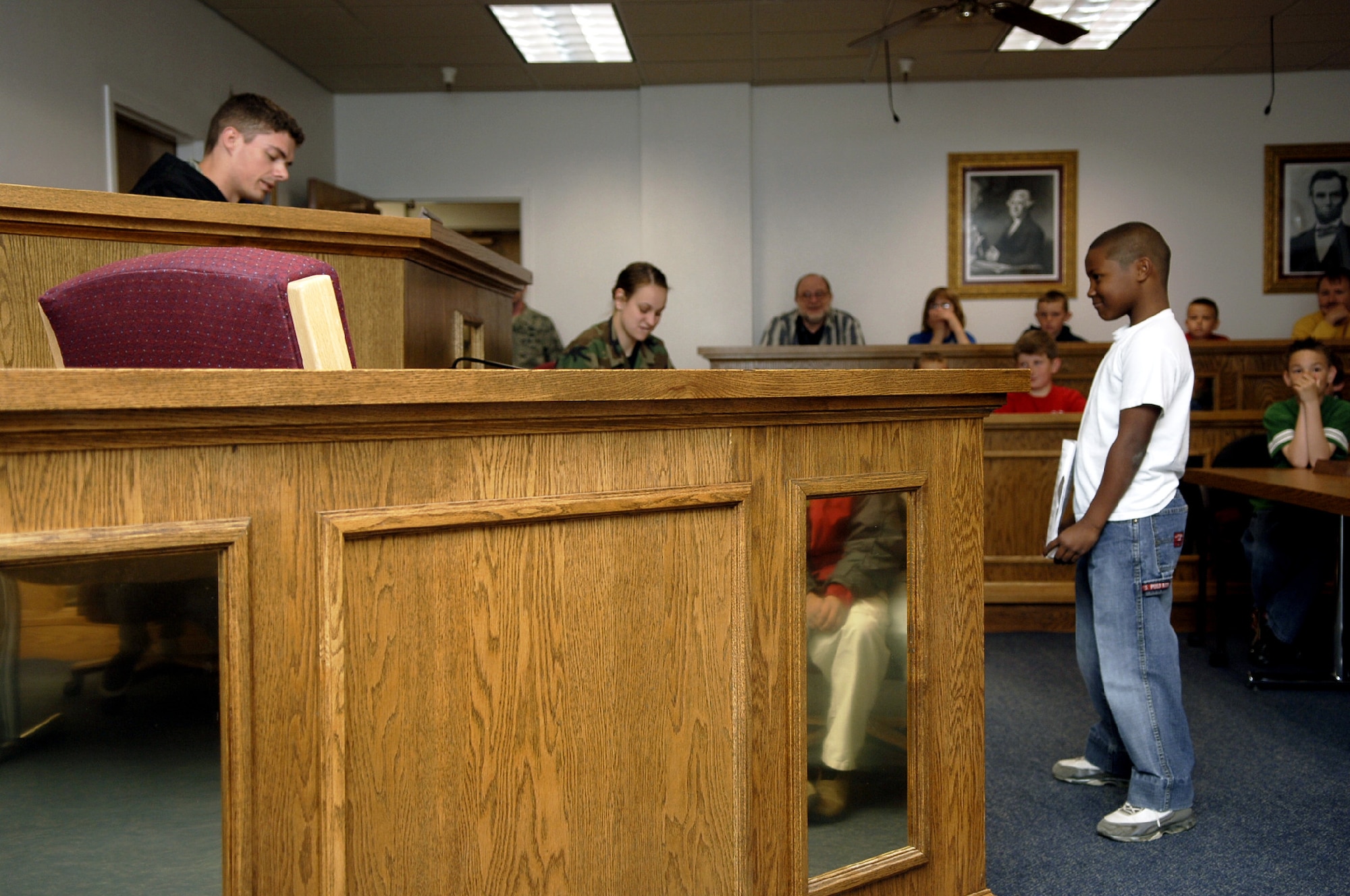 MOUNTAIN HOME AIR FORCE BASE, Idaho -- (Right) Trevaun Walker, a fourth grader from the Base Primary School who is on trial as Jack from the children’s story Jack and the Beanstalk, listens while Staff Sgt. Steven Bayne, 366th Fighter Wing noncommissioned officer in charge of military justice, reads the charges brought against him during a mock trail hosted by the 366th FW Legal Office, which is trying to determine if Jack is guilty of murdering the ogre as part of Law Day April 30. After deliberation, Jack was found innocent. Sponsored by the American Bar Association, Law Day is held May 1, and this year’s theme was “The Rule of Law: Foundation for Communities of Opportunity and Equity.” Children also made posters depicting their favorite laws. (U.S. Air Force photo/Airman 1st Class Samantha S. Crane)