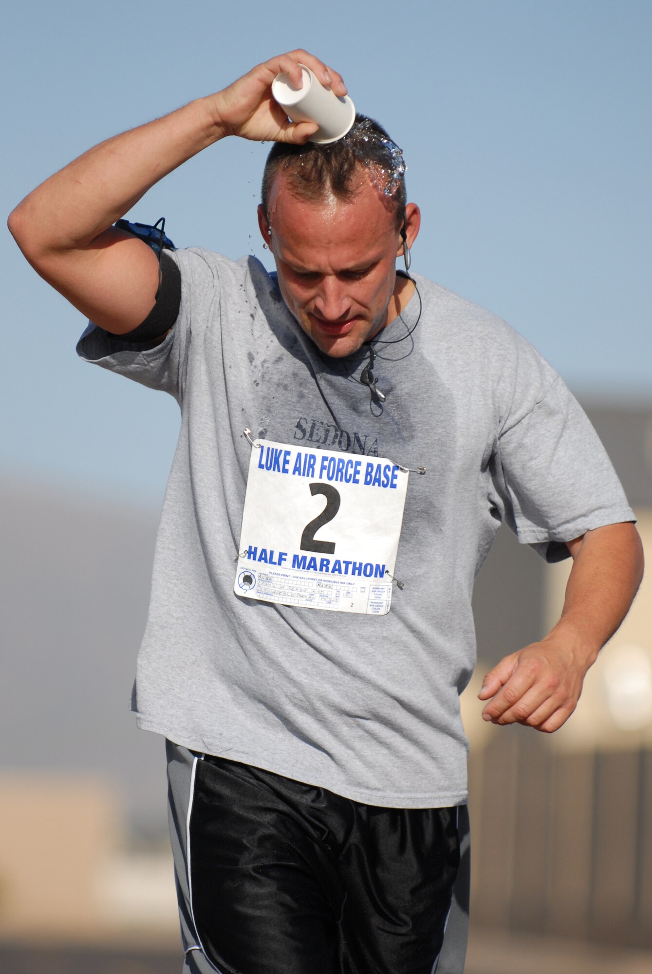 Technical Sergeant Mark Aube, an electrical environmental technician with the 309th Aircraft Maintenance Unit, cools off with a cup of water during the half marathon held at Luke Air Force Base, Ariz., May 3. Fifty four runners logged more than 700 miles during the Saturday run.(U.S. Air Force Photo/ Staff Sergeant Jerry Fleshman)