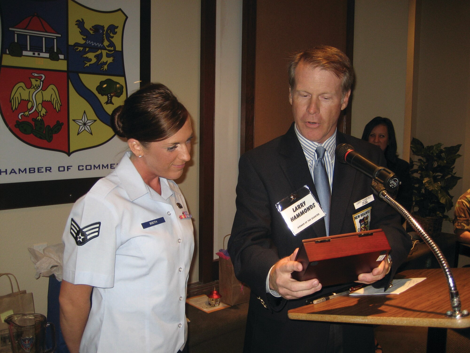 Senior Airman Jennifer Booth receives a gift box from Larry Hammond, vice chairman of the New Braunfels, Texas, Chamber of Commerce during a reception honoring her as Randolph Airman of the Year for 2007. The engraving on the box said, “Leadership: Leaders are like eagles; they don’t flock. You find them one at a time.” 