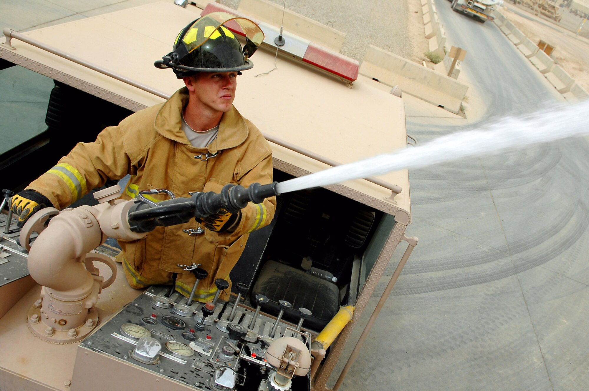 Army Spc. James Taylor aims and discharges a deck gun during hose advancement and pump training April 29 at Balad Air Base, Iraq. The deck gun can pump 1,000 gallons of water per minute and is used most often when putting out large blazes. Specialist Taylor is an 8th Ordnance Company firefighter deployed from Fort Bragg, N.C. (U.S. Air Force photo/Senior Airman Julianne Showalter) 

