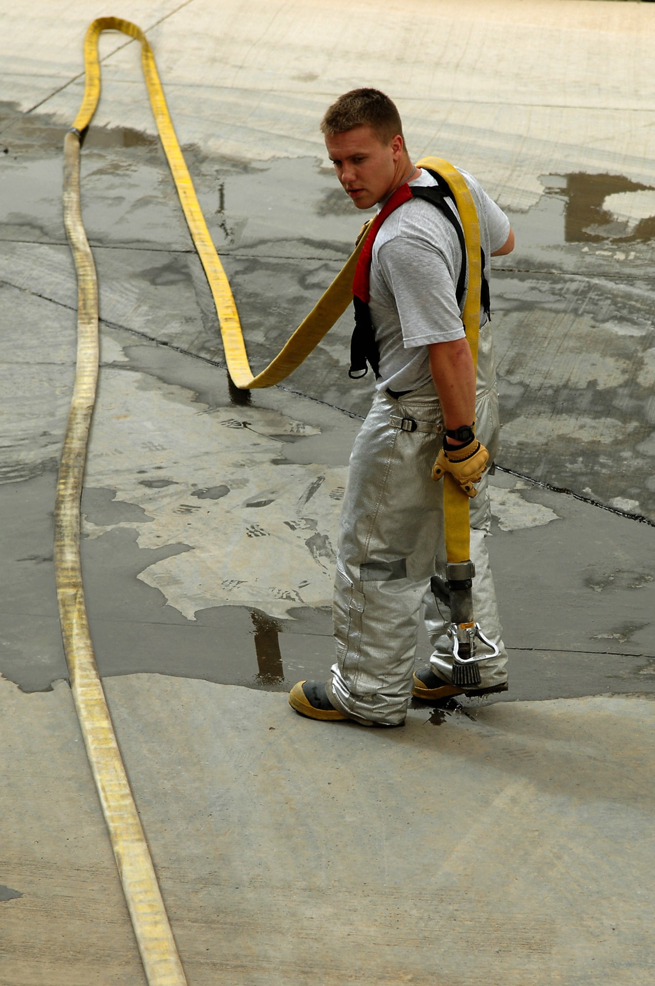 Airman 1st Class Adam Baumgardner wraps up a hose during advancement and pump training April 29 at Balad Air Base, Iraq. Training on a daily basis helps firefighters stay mission ready for emergency situations. Airman Baumgardner is a 332nd Expeditionary Civil Engineer Squadron firefighter deployed from Malmstrom Air Force Base, Mont. (U.S. Air Force photo/Senior Airman Julianne Showalter) 
