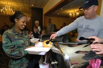 MINOT AIR FORCE BASE, N.D. -- Airman Simret AmDemichael, 5th Communications Squadron, smiles as she takes a break from work to eat breakfast, served up by Chief Master Sgt. Robert C. Rohn, 5th Maintenance Group here May 2.  The Chief's group provides this breakfast twice a year to help the enlisted corps of Minot AFB.  (U.S. Air Force photo by Airman 1st Class Kelly Timney)