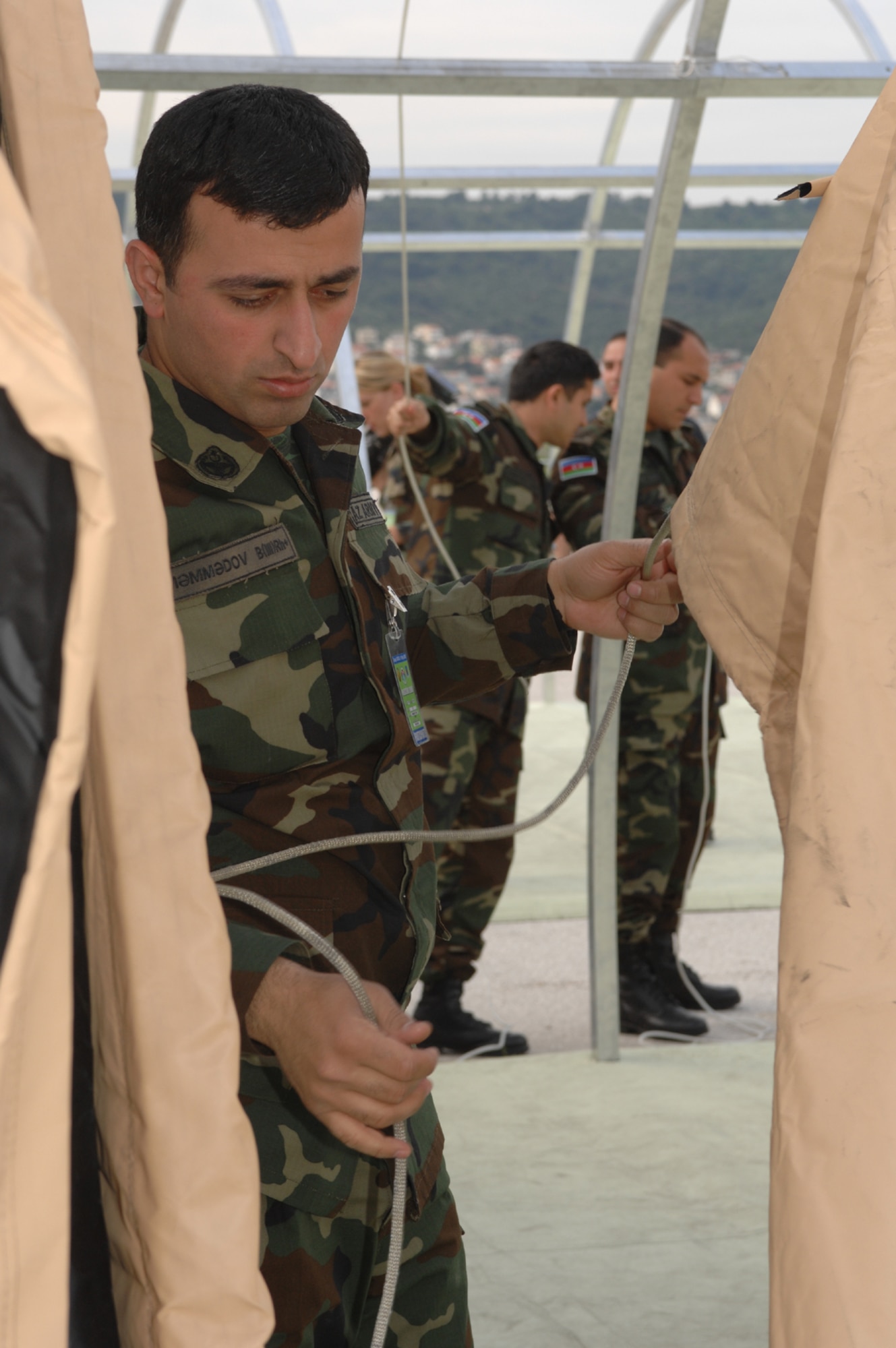 IVULJE TRAINING BASE, Croatia – Azerbaijani Army 1st Lt. Elmir Mammadov learns how to assemble an Expeditionary Medical Squadron (EMEDS) +10 tent May 5 during the 2008 Medical Training Exercise in Central and Eastern Europe (MEDCEUR).  The EMEDS training course is one of eleven courses offered during MEDCEUR.  Fifteen nations are participating in the exercise from May 2 through 14. The exercise focuses on mass-casualty training scenarios and humanitarian aid in response to crises situations. MEDCEUR is a Joint Chiefs of Staff regional/multilateral exercise sponsored by U.S. European Command. Croatia is hosting the 2008 exercise which has drawn about 400 multi-nationals in support of the Partnership for Peace initiative. (U.S. Air Force photo/Staff Sgt. Kristin Ruleau)
