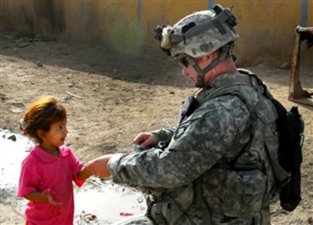 U.S. Army Sgt. 1st Class Lyle Whitted gives a little Iraqi girl a piece of gum during a search of several houses in Jabella, Iraq, May 2, 2008. Whitted is assigned to the 502nd Infantry Regtiment. 

