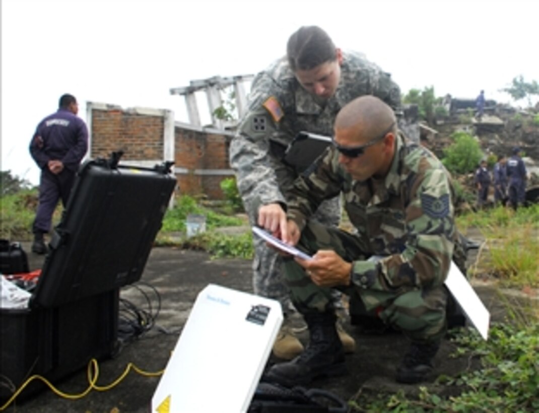 U.S. Air Force Tech. Sgt. Mike Vaughn and Army Capt. Sarah Williams, Joint Task Force-Bravo civil engineers, set up a field video teleconferencing unit at an abandoned coffee factory, May 5, 2008, at Comalapa Air Base, El Salvador, during Fuerzas Aliadas Humanitarias 2008, a regional disaster relief exercise being conducted through May 15. 