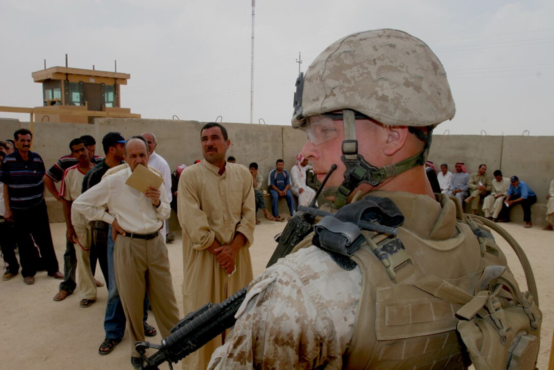 Lance Cpl. Derek B. Wilson, 20, from Lincoln Neb., who is a civil affairs representative with Civil Affairs Team 1, Detachment 1, 2nd Battalion, 11th Marine Regiment, Regimental Combat Team 5, watches the crowd of people who are waiting in line to have identification badges made at the Civil Military Operations Center, Haditha, Iraq, May 6. The CMOC was opened to issue ID badges, vehicle registration stickers and also gave a venue to military forces to communicate with the people of Haditha and the surrounding areas.