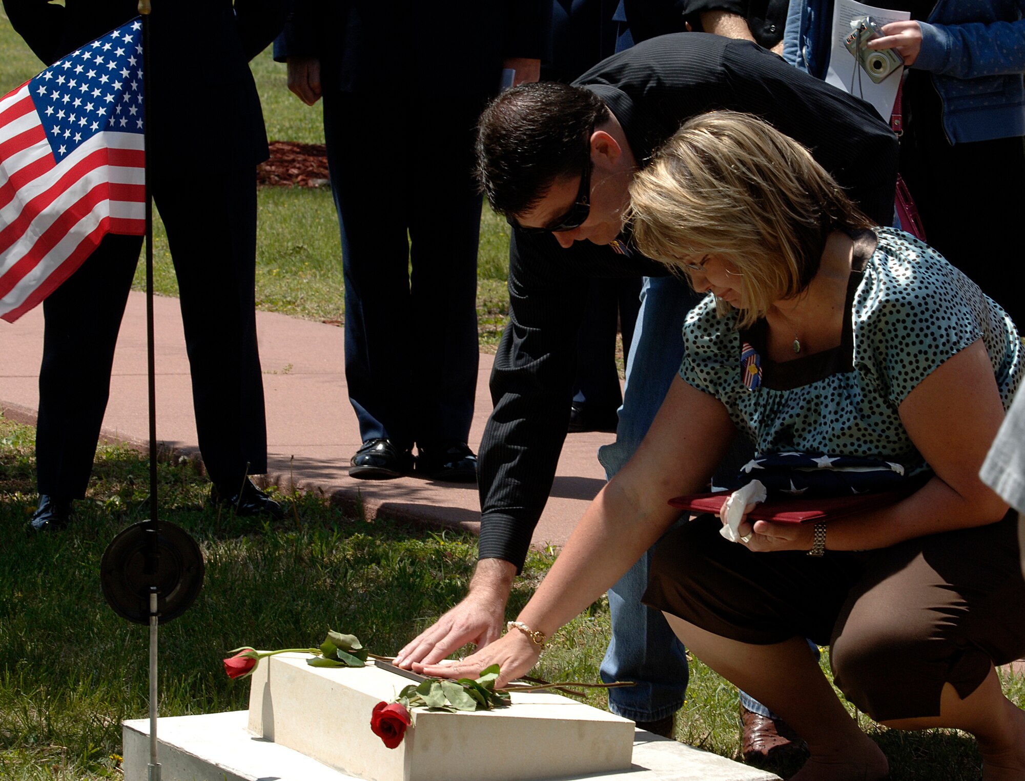 MCCONNELL AIR FORCE BASE, Kan. -- John and Natalie Perry, parents of the late Senior Airman Jonathan Blake Perry, 22nd Aircraft Maintenance Squadron, communication and navigation systems specialist, lay red roses on the stone marker dedicated to him at the Memorial Walk, May 4.  (Photo by Airman Justin Shelton)