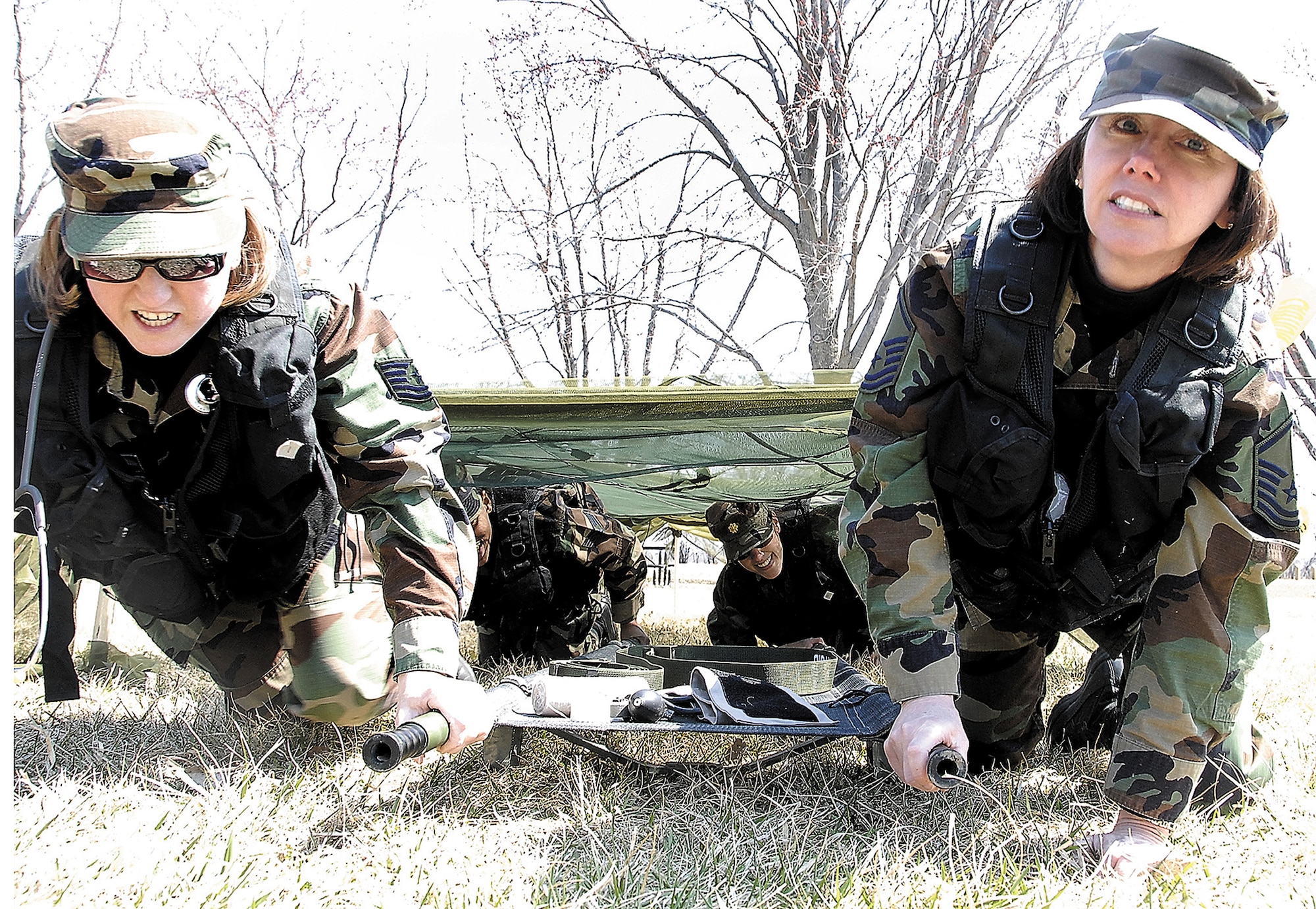 710th Medical Squadron reservists, Tech. Sgt. Kristine Fleming, operating room technician, and Master Sgt. Jean Tait, NCOIC of Medical Logistics, and their team emerge from the low-crawl portion of the litter-carry obstacle course during a field training exercise at Offutt Air Force Base, Neb., as the last step to reaching their waiting "patient." After treating the patient and placing him on the stretcher, the team would have to retrace their route, including repeating the low-crawl, to carry him to safety. The 710th is an Air Force Reserve Command squadron based at Offutt and is a geographically-separated unit assigned to the 442nd Fighter Wing at Whiteman AFB, Mo. (US Air Force photo/Tech. Sgt. John Vertreese)