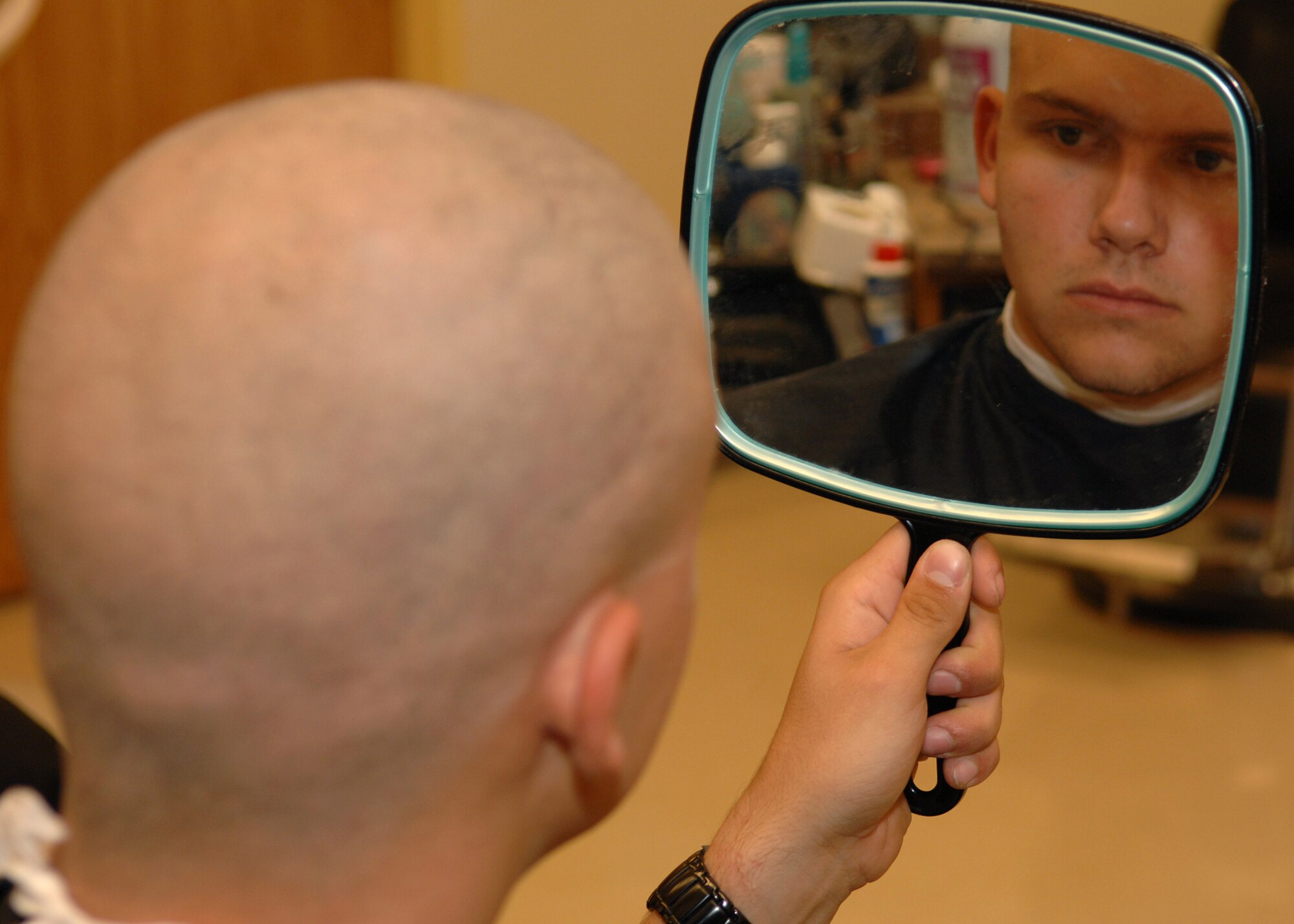 DYESS AIR FORCE BASE, Texas -- Airman 1st Class Micheal Breaux takes a look at his new haircut at the Base Exchange barber shop May 7. (U.S. Air Force Photo by Airman 1st Class Stephen Reyes)