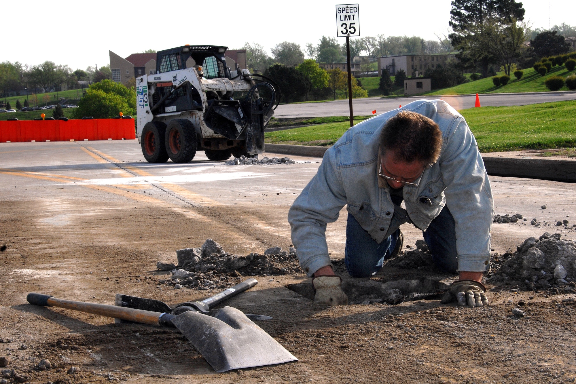Mike Wollery, a maintenance and equipment staff member from the 55th Civil Engineer Squadron, removes broken concrete from a pot hole near the corner of SAC Boulevard and Peacekeeper Drive here May 6. The Civil Engineer Squadron is working hard to repair the roads on Offutt after a brutal winter. (U.S. Air Force Photo By/Josh Plueger)