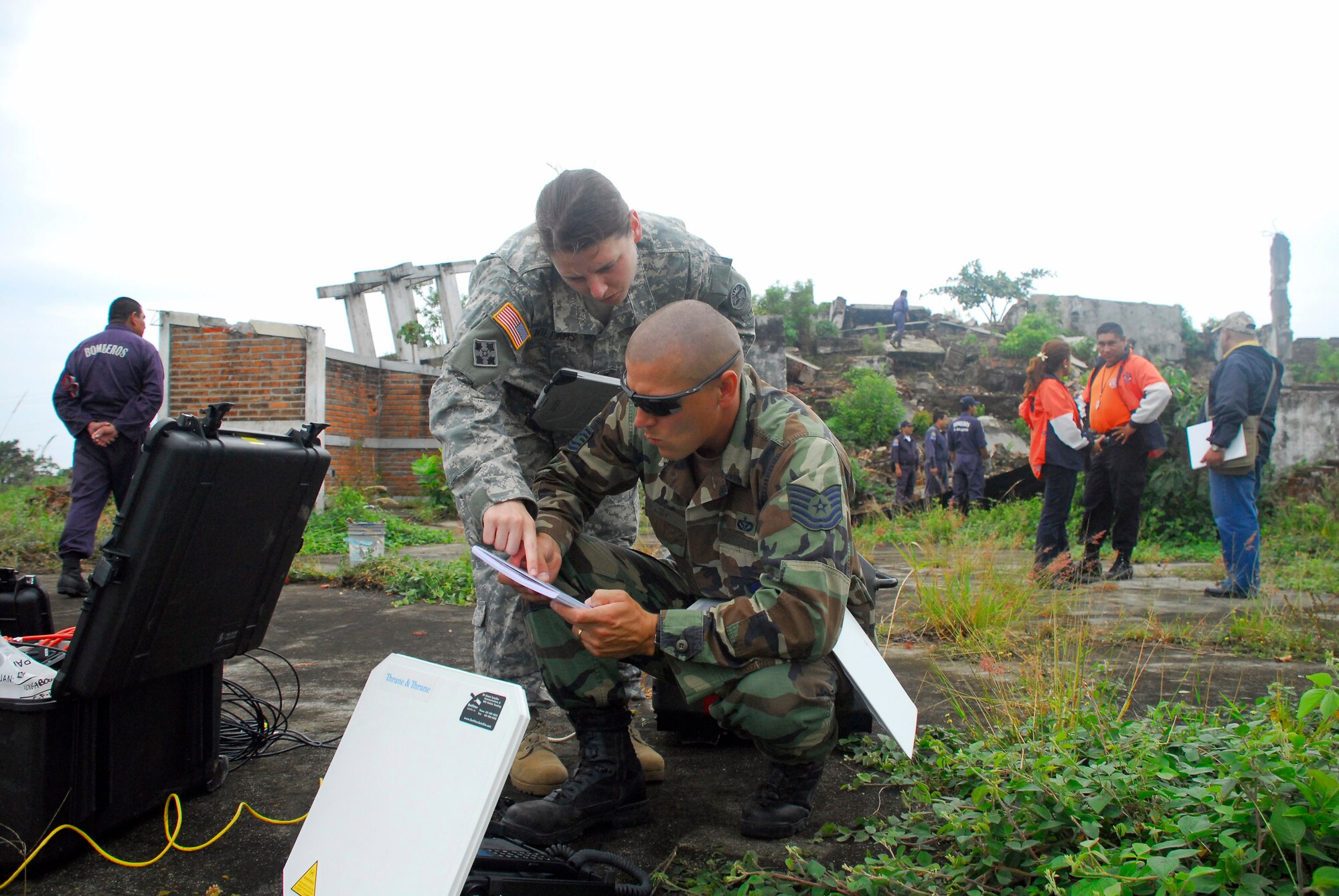 Tech. Sgt. Mike Vaughn and Army Capt. Sarah Williams set up a field video teleconferencing unit to send imagery gathered here to the United States to assist with the exercise Fuerzas Aliadas Humanitarias 2008 May 5 from the grounds of a collapsed and abandoned coffee factory in El Salvador. The regional disaster relief exercise involved military and civilian agencies from the region. By capturing imagery of damage from a 2001 earthquake, participants in the exercise have a simulated yet realistic view of damage to help them make accurate decisions regarding the relief process. Sergeant Vaughn and Captain Williams are Joint Task Force-Bravo civil engineers. (U.S. Air Force photo/Tech. Sgt. William Farrow) 
