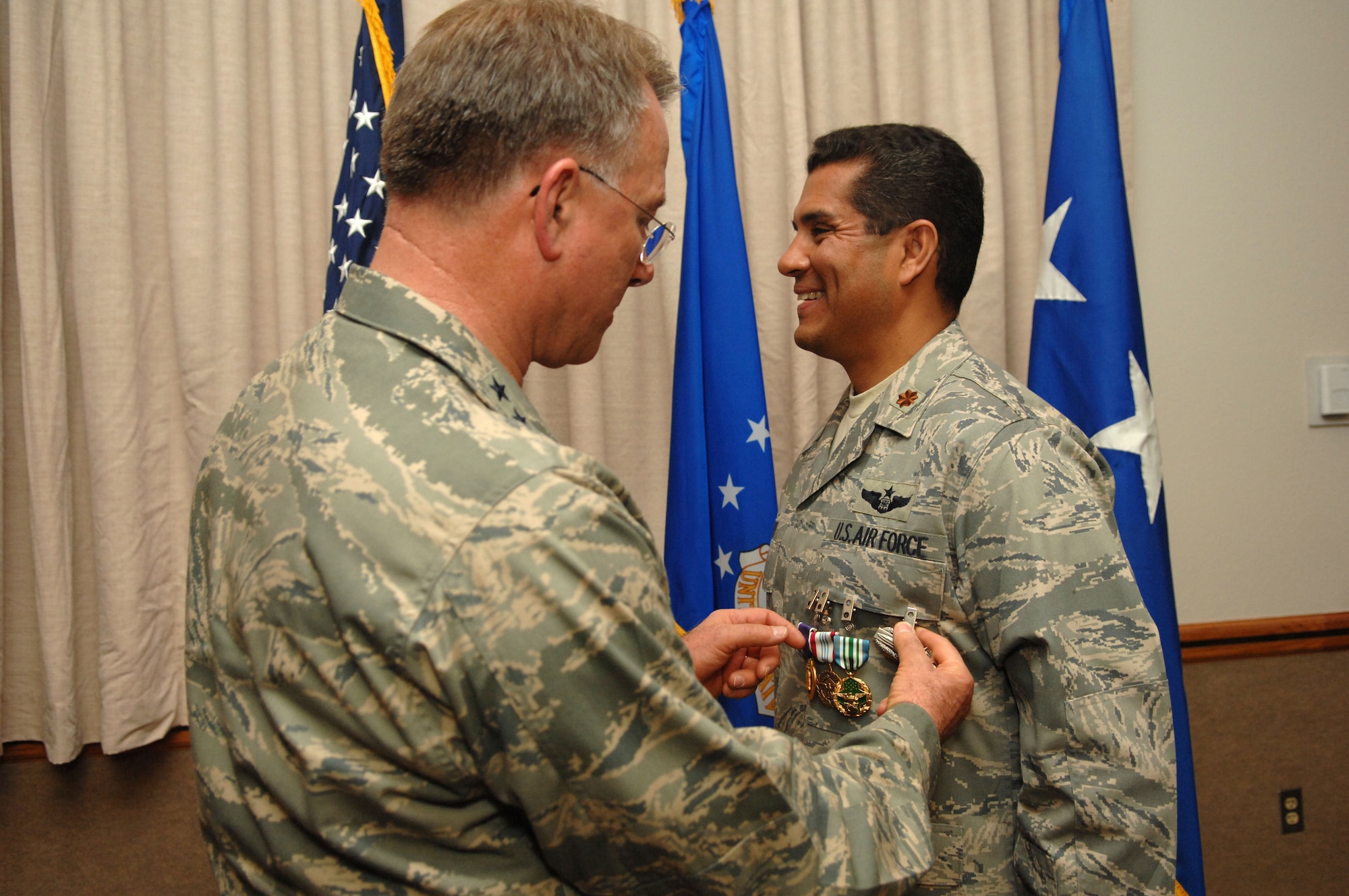 NELLIS AIR FORCE BASE, Nev. -- Lt. Gen. John Bradley, Air Force Reserve Command commander, pins the Combat Action Badge on Maj. Anthony Jones, 99th Air Base Wing chief of exercise plans and programs, during a ceremony at the Officers Club here Monday. Major Jones was awarded six decorations for his heroic actions while deployed to Camp Victory, Iraq. (U.S. Air Force Photo by/Senior Airman Larry E. Reid Jr.)