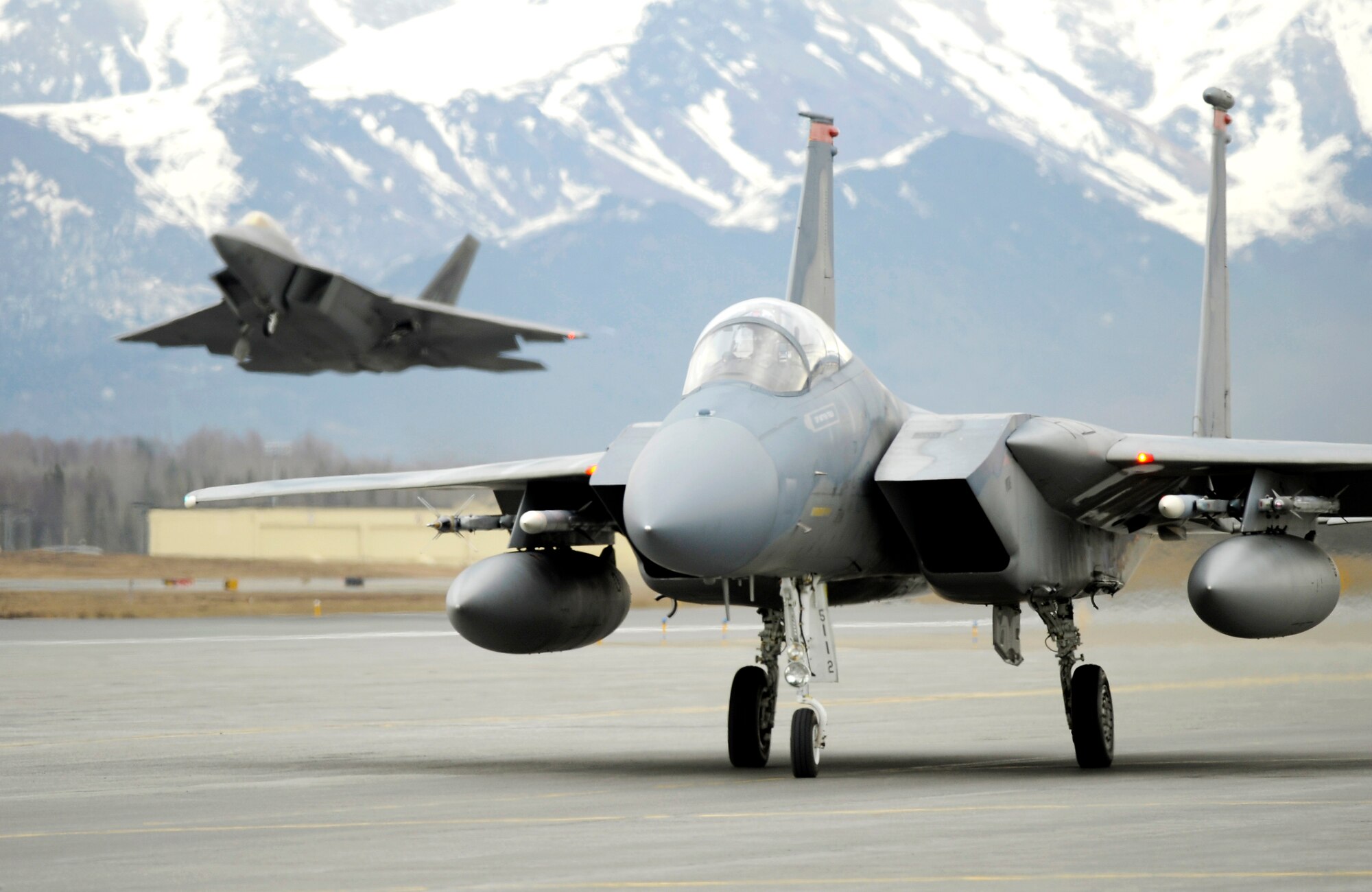 ELMENDORF AIR FORCE BASE, ALASKA -- An F-15 from Kadena Air Force Base, Japan taxis as an F-22 takes off for Northern Edge '08. The F-22 is assigned to the 90th Fighter Squadron here.