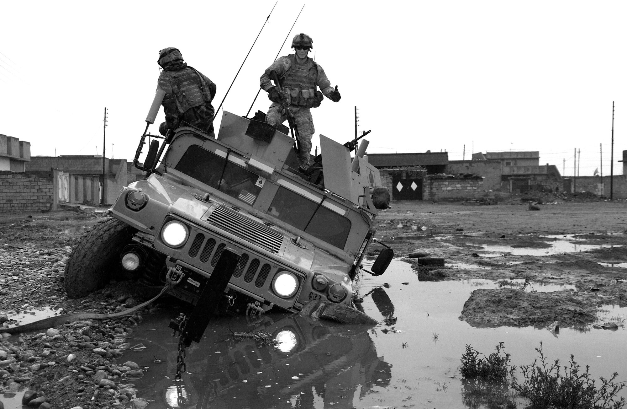 U.S. Army soldiers dismount from their Humvee after getting stuck in a mud hole while patrolling through Kirkuk, Iraq, on Dec. 28, 2006.  The soldiers are from Charlie Company, 2nd Battalion, 35th Infantry Regiment, 25th Infantry Division.  DoD photo by Staff Sgt. Samuel Bendet, U.S. Air Force.  (Released)