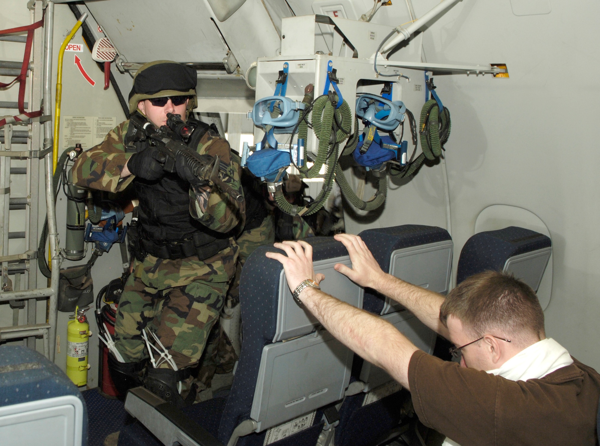 During aircraft interdiction training, Senior Airman John Passmore, 305th Security Forces Squadron, breaches the entry door of a KC-10A Extender recently at McGuire Air Force Base, N.J. The training prepared McGuire and Fort Dix security team members to resolve high-risk incidents involving hijacked aircraft. (U.S. Air Force photo/Kenn Mann)